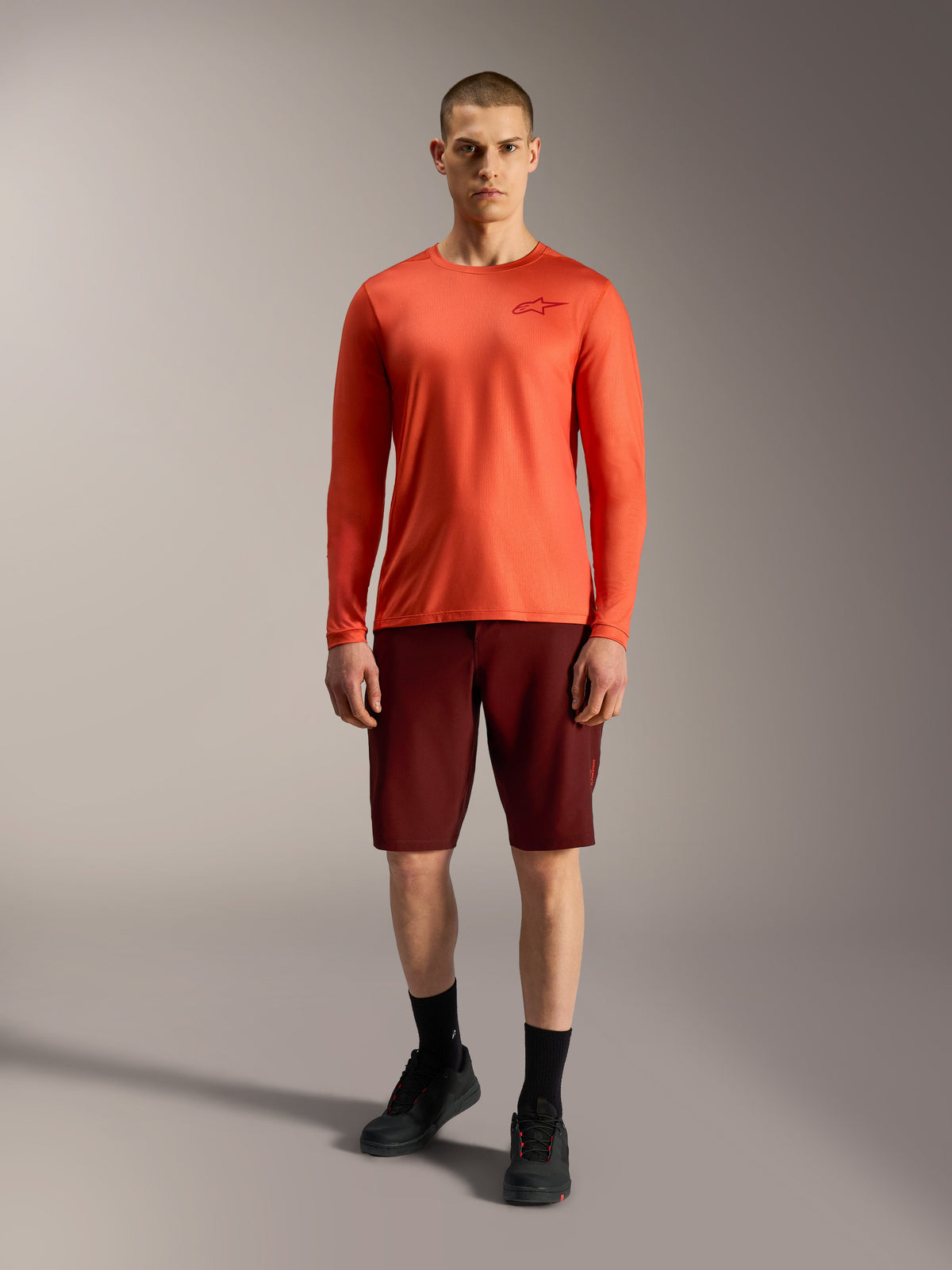 Alpinestars A-Dura Ride Shorts in Bordeaux and orange jersey, engineered for durable mountain bike performance.