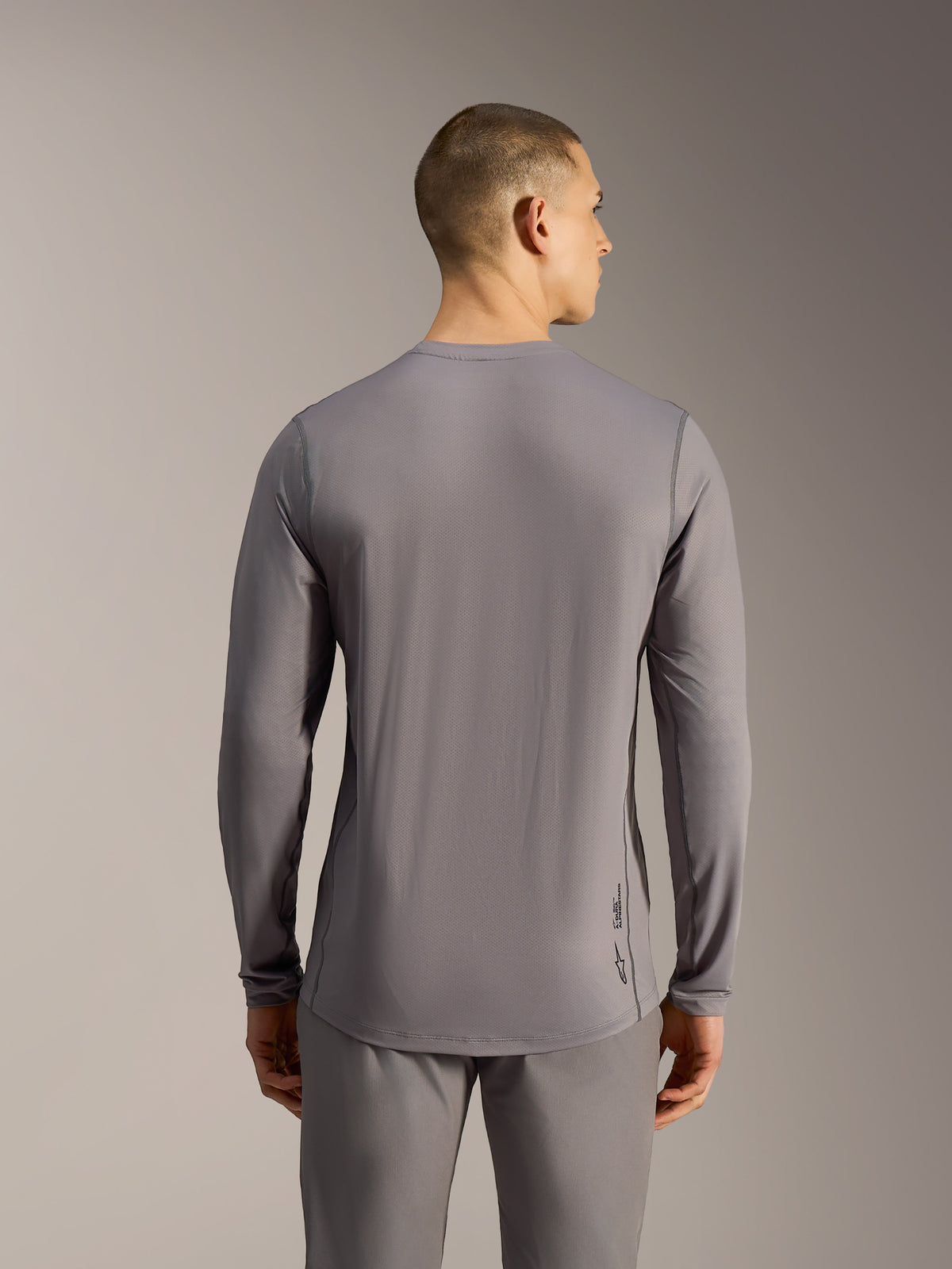 Maillot VTT A-Dura Ride à manches longues gris, tissu jacquard extensible et ourlet arrière allongé, vue de dos.