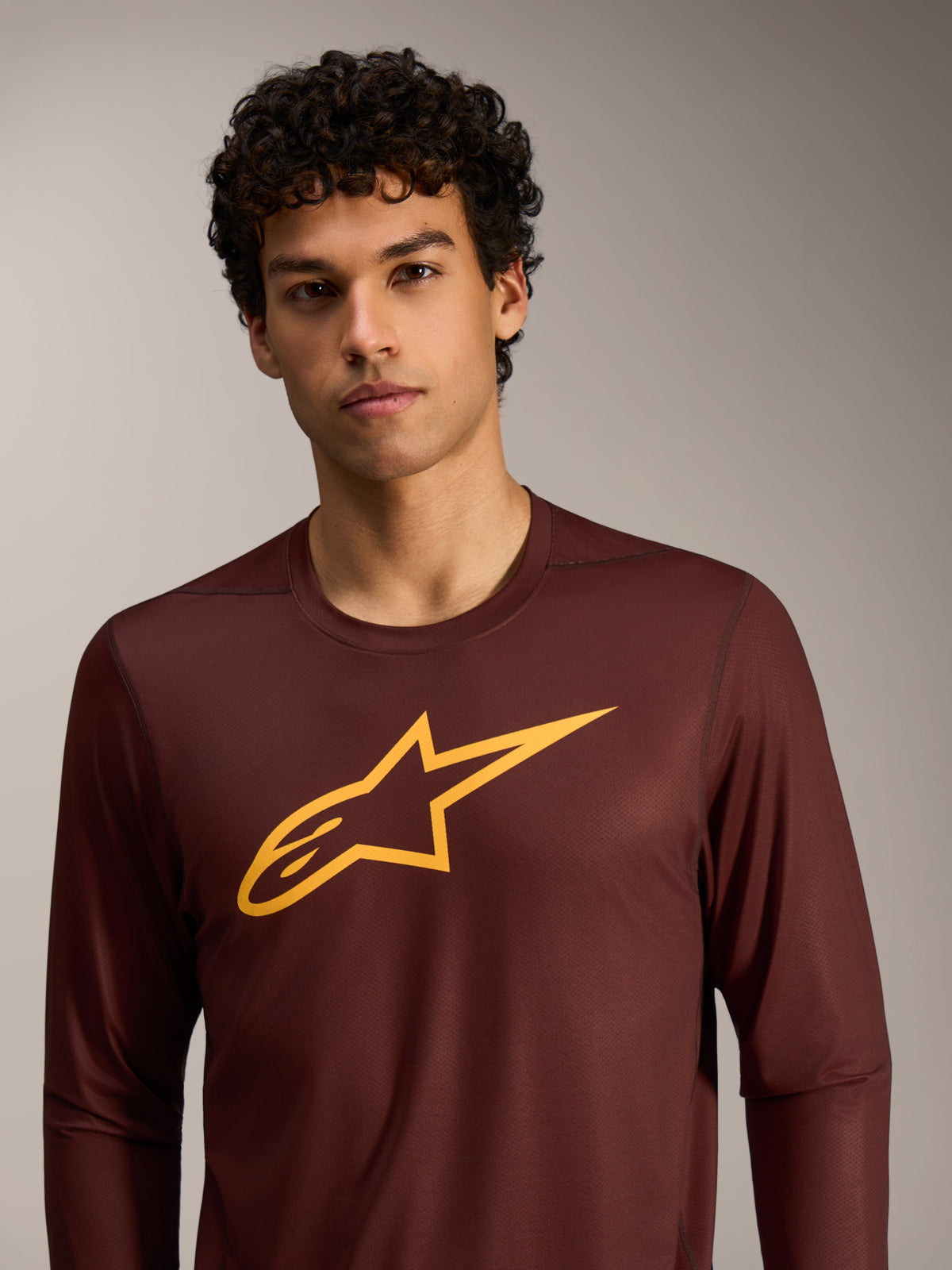 Bordeauxrotes A-Dura Ride Langarmtrikot mit gelbem Alpinestars-Logo auf der Brust, Performance-MTB-Bekleidung.