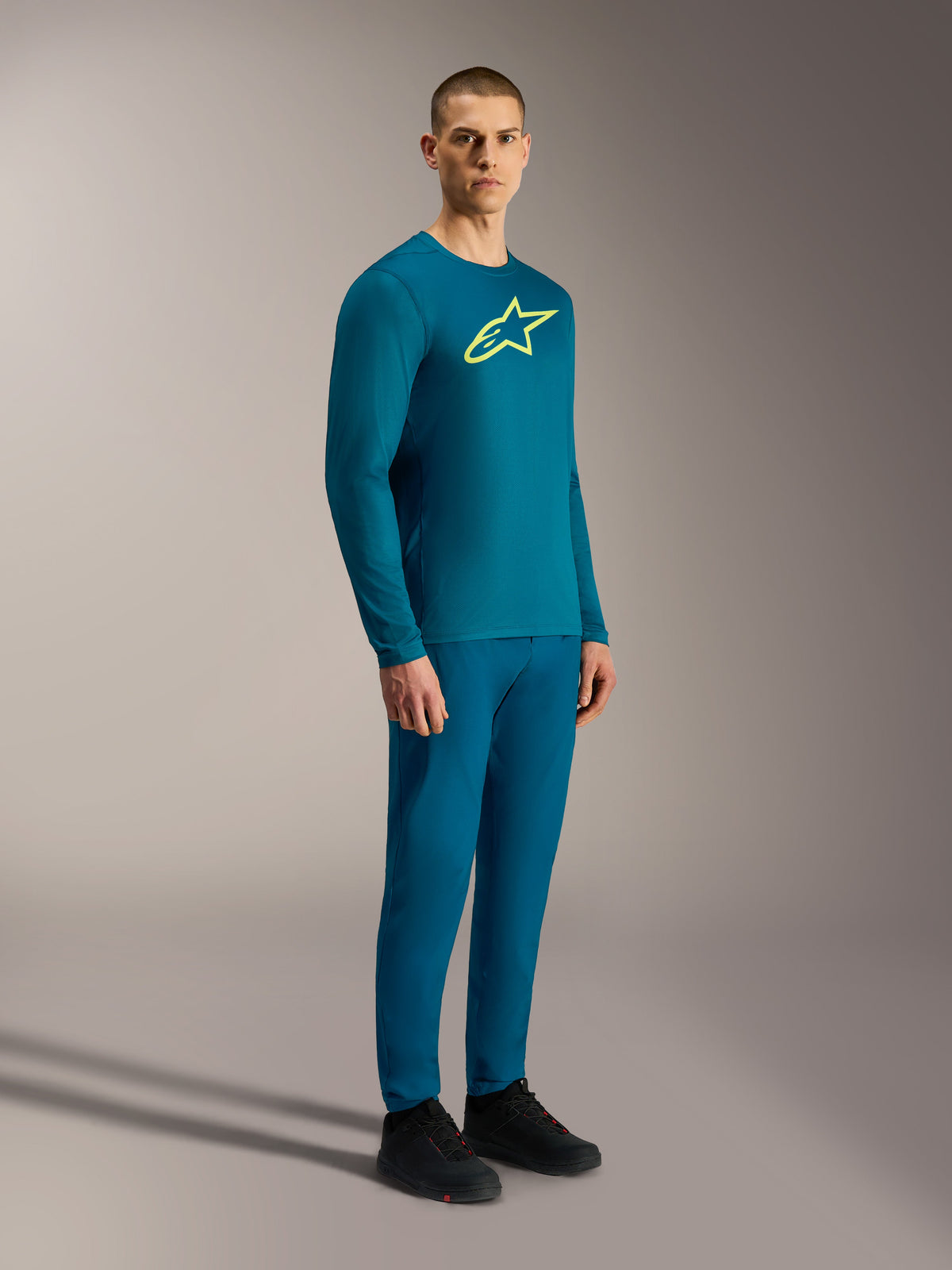 A-Dura Ride Long Sleeve Jersey in Blue Green with a yellow Astars logo, worn with matching performance MTB gear.