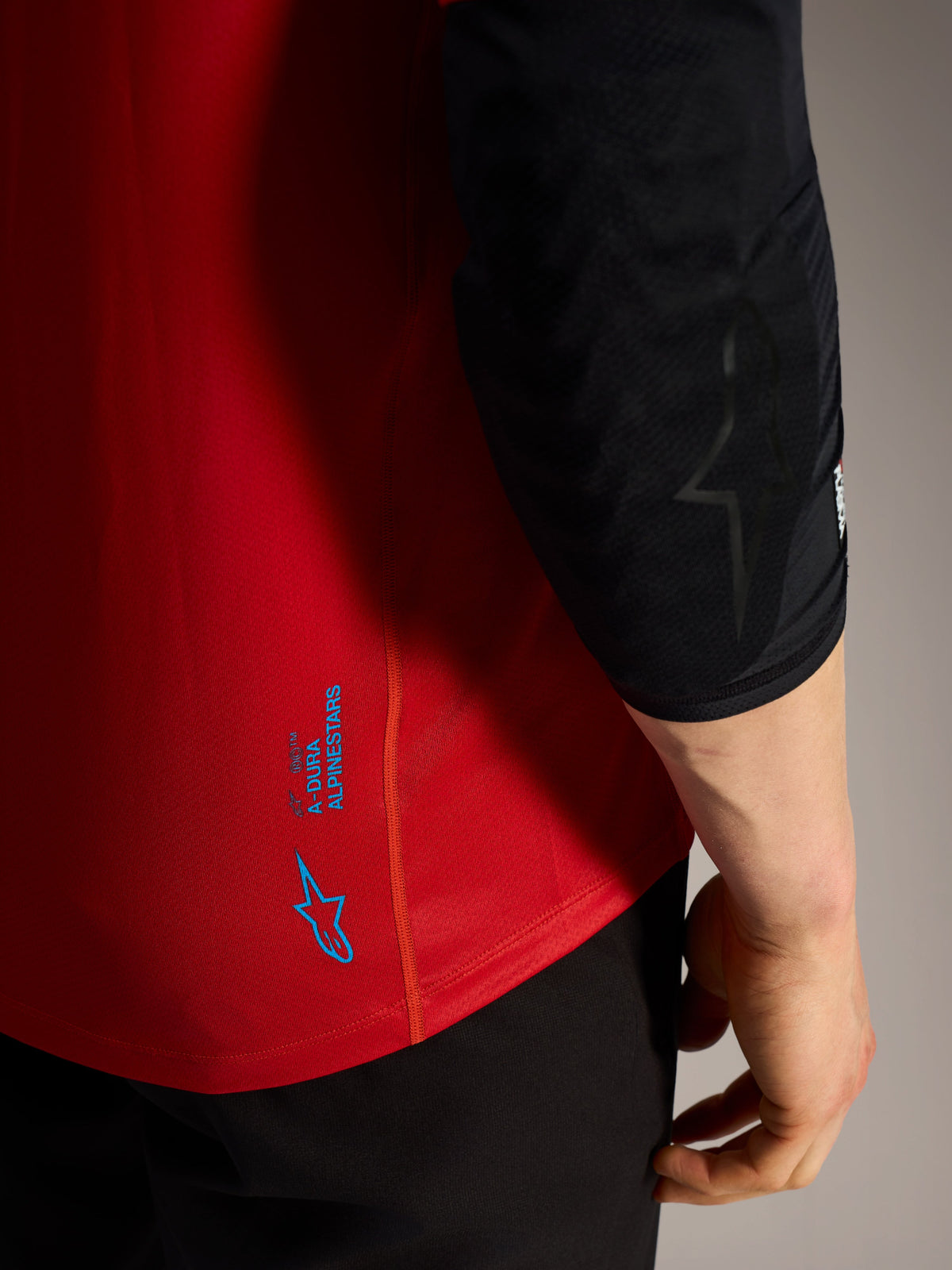 Rode A-Dura Ride MTB-trui met korte mouwen, voorzien van blauwe Alpinestars logo's en technische stretchstof.