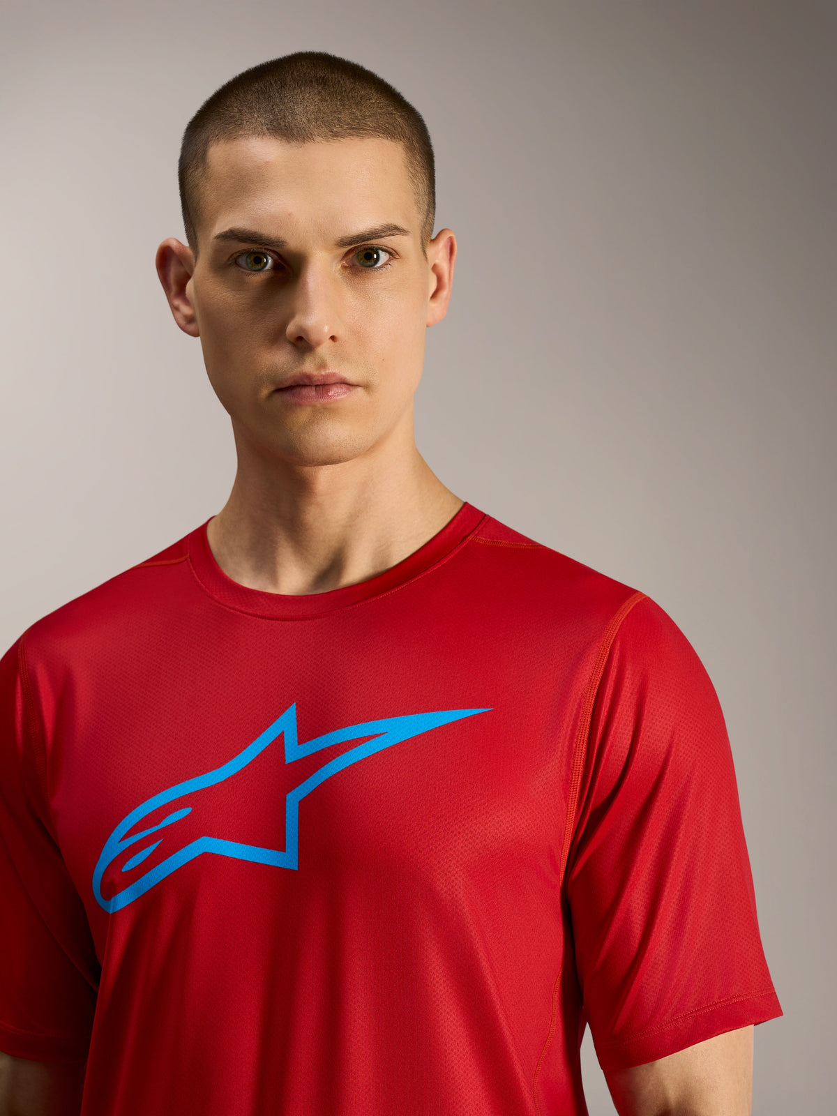 Rode A-Dura Ride trui met korte mouwen en blauw Alpinestars-logo, technische kleding voor MTB-trails.