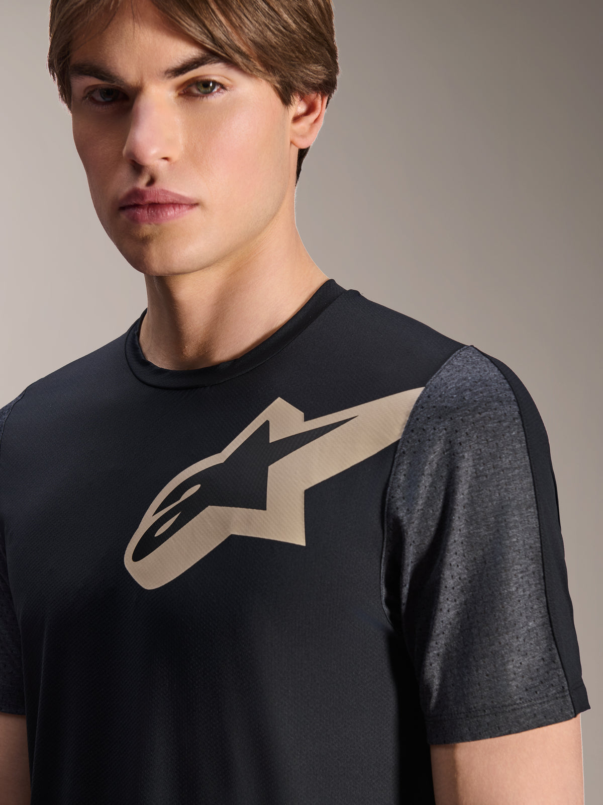 Maillot Alpinestars A-Dura Lipan - Manches courtes, noir, avec logo Astars beige sur la poitrine et manches perforées gris foncé chiné, vêtement de performance pour VTT