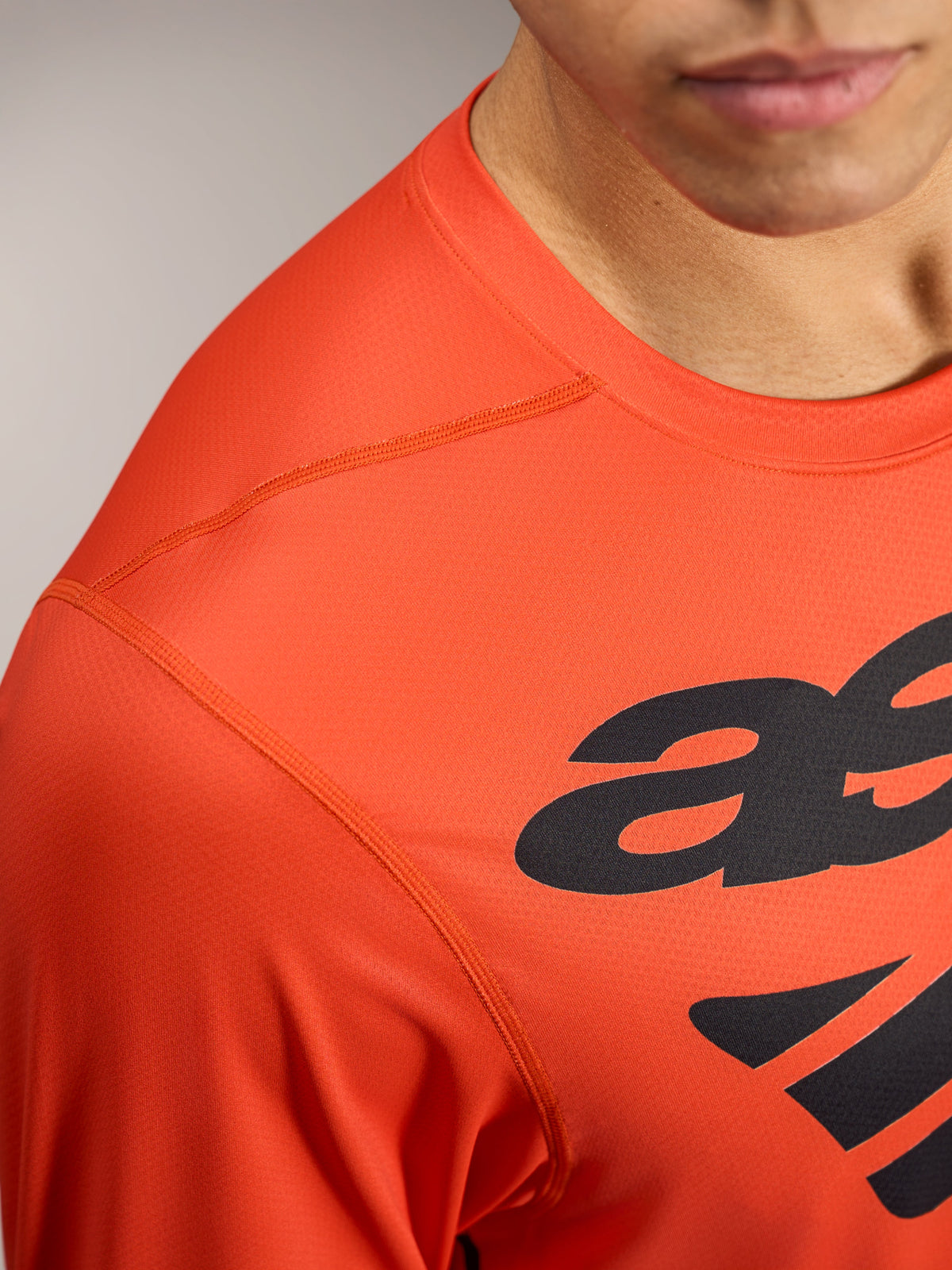 Orange A-Dura ASTARS Long Sleeve Jersey 2.0 featuring black logo graphics and breathable, textured performance fabric.