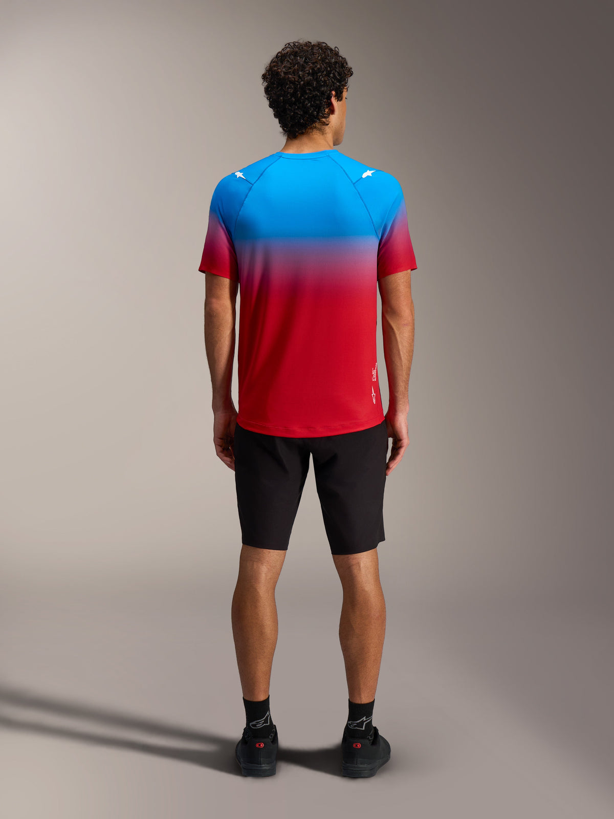 A-Dura ASTARS Jersey 2.0, MTB-top met rood-blauw kleurverloop en korte mouwen, achteraanzicht met zwarte short.