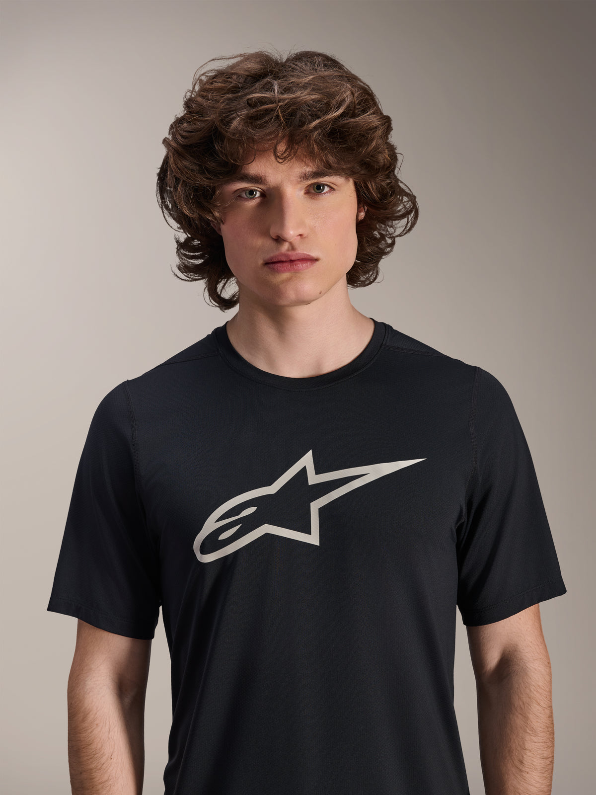Alpinestars A-Dura Astar jersey met korte mouwen, zwart, voorzien van een groot wit Astar-logo op de borst, gedragen door een mannelijk model, casual mountainbike-performancekleding