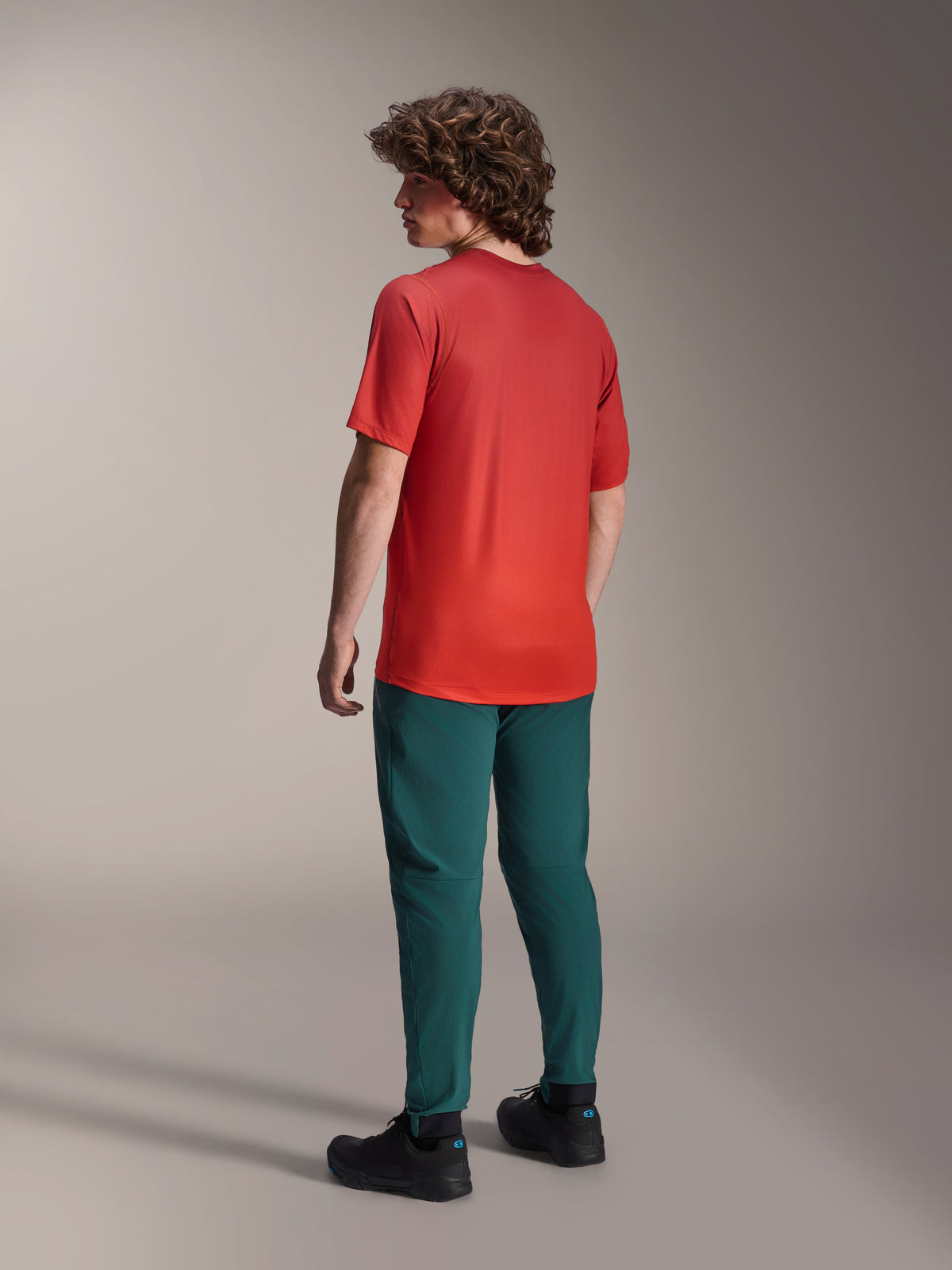 Model van achteren gezien in de Alpinestars A-Dura Pants in Dark Pine groen en een rood A-Dura Rise Short Sleeve Jersey, voorzien van een normale pasvorm en elastische manchetten, performance mountainbike-kleding voor off-road rijden