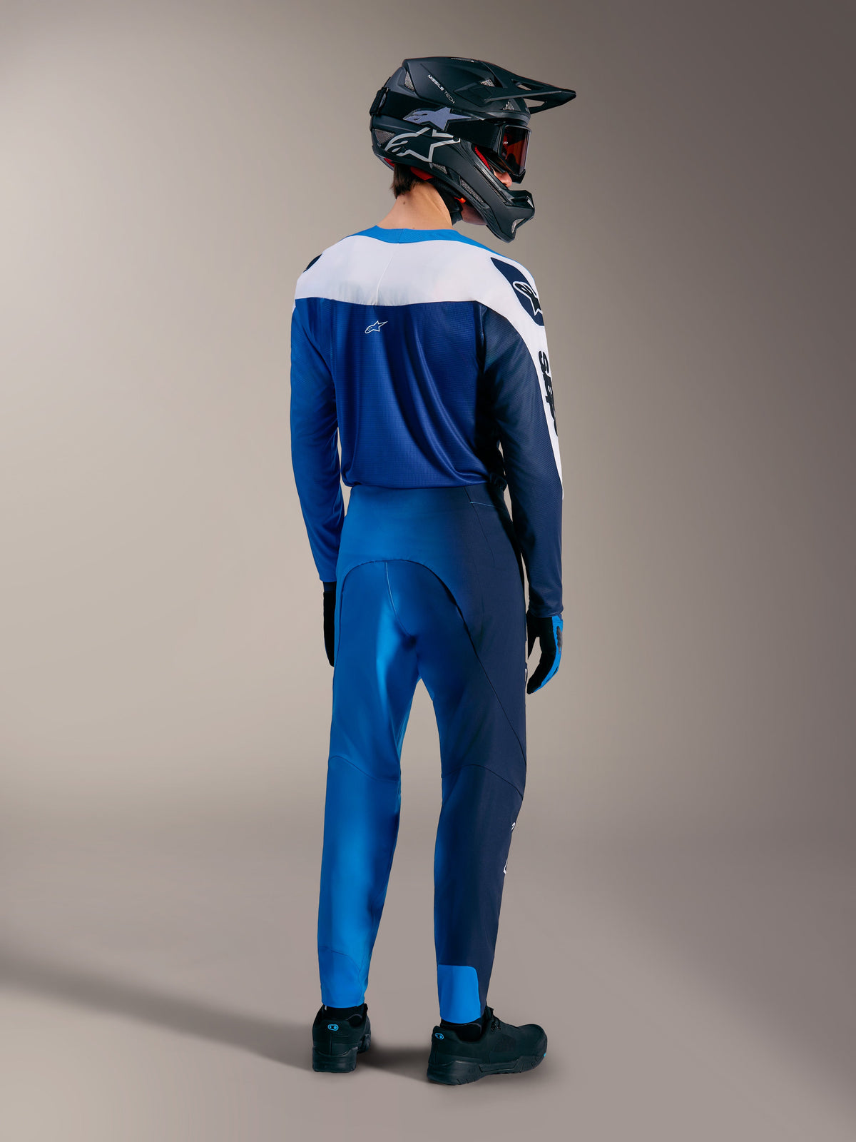 A-Supra Elite MTB-Ausrüstung in Faded Bright Blue mit passendem Trikot, Hose und Fullface-Helm von hinten.