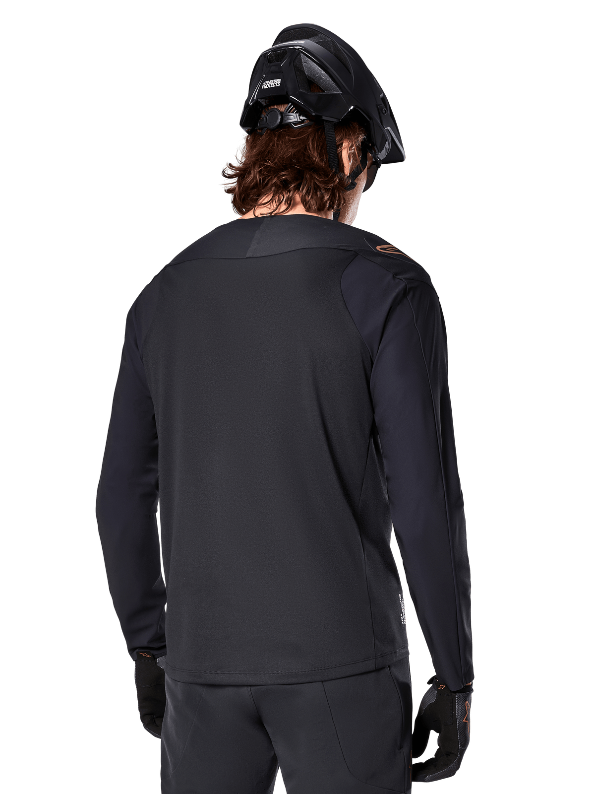 Maillot à manches longues Alpinestars A-Aria Polartec Switch, noir, vue de dos, porté avec un casque de VTT et des gants noirs, doté d'une coupe à pan arrière allongé pour la performance tout-terrain
