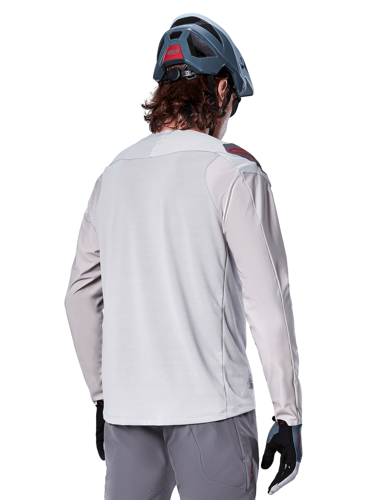 Alpinestars A-Aria Polartec Switch Langarmtrikot, Hellgrau, Rückansicht an einem Fahrer, getragen mit einem blauen Mountainbike-Helm und grauer Hose, Performance-Mountainbike-Bekleidung für Offroad-Trails