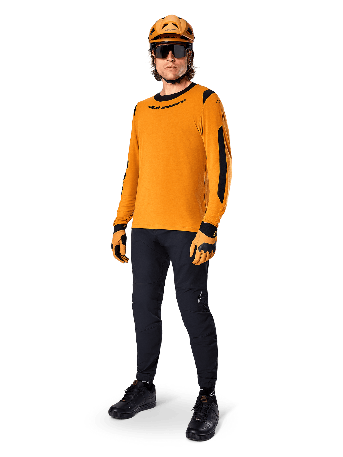 Alpinestars A-Dura Dri Wool Jersey - Long Sleeve, or foncé, porté avec un casque orange assorti, un pantalon de VTT noir et des gants jaunes et noirs, tenue de cyclisme complète pour le tout-terrain