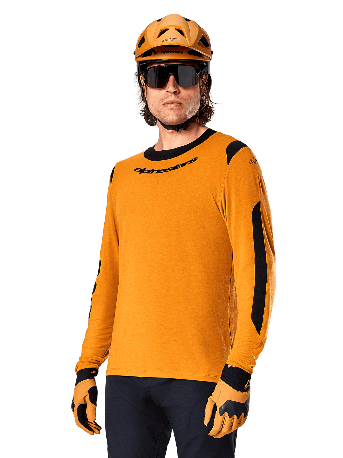 Alpinestars A-Dura Dri Wool Jersey - Long Sleeve, maillot de VTT à manches longues, or foncé et noir, doté d'un mélange de laine mérinos évacuant l'humidité et de panneaux en maille, cycliste portant un casque, des lunettes de soleil et des gants assortis