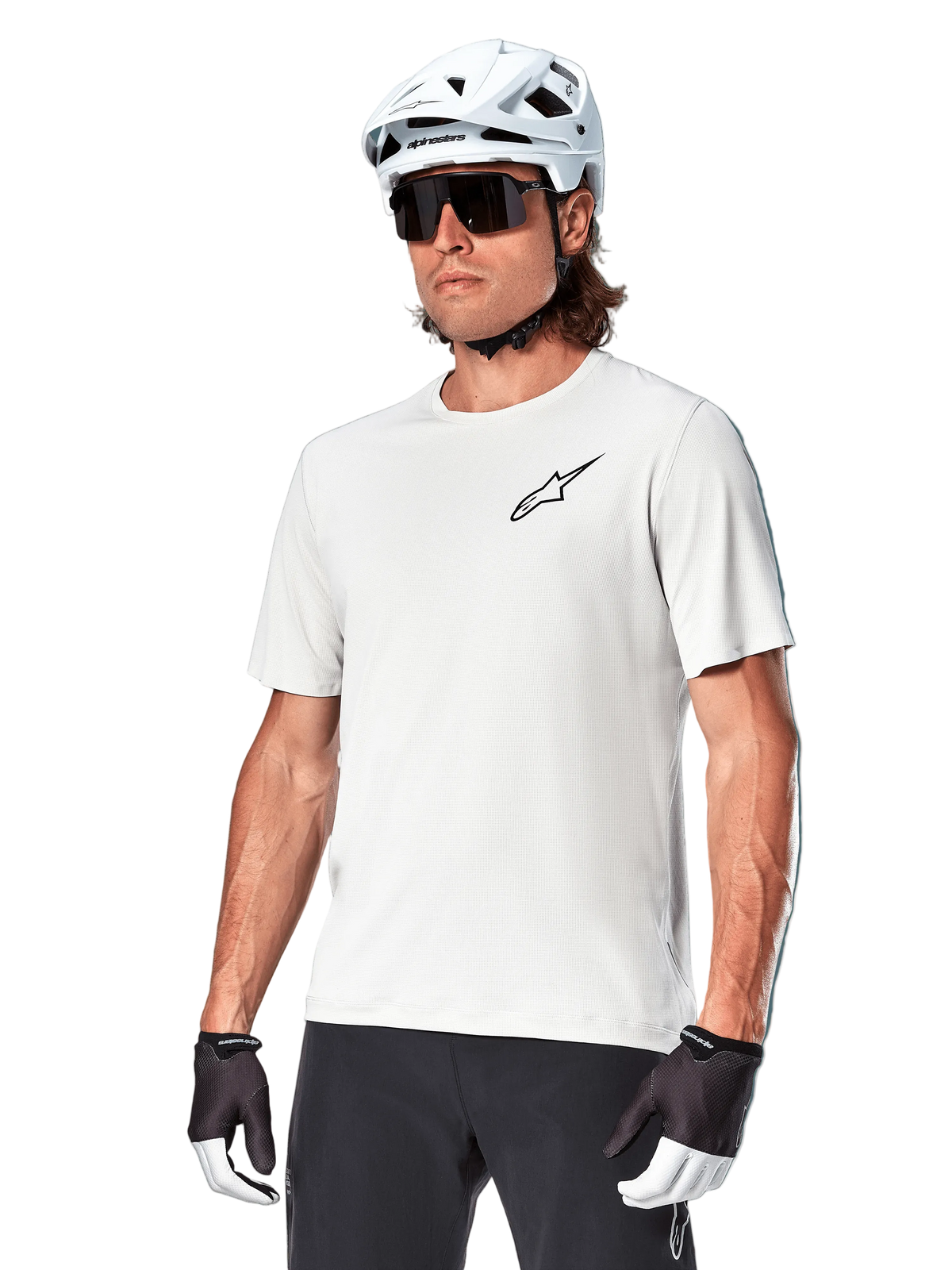 Alpinestars A-Aria Astar Jersey met korte mouwen, White Dove, gedragen door een fietser met een witte helm en donkere zonnebril, voorzien van een klein zwart ster-logo op de borst, ademende performance-kleding voor mountainbiken