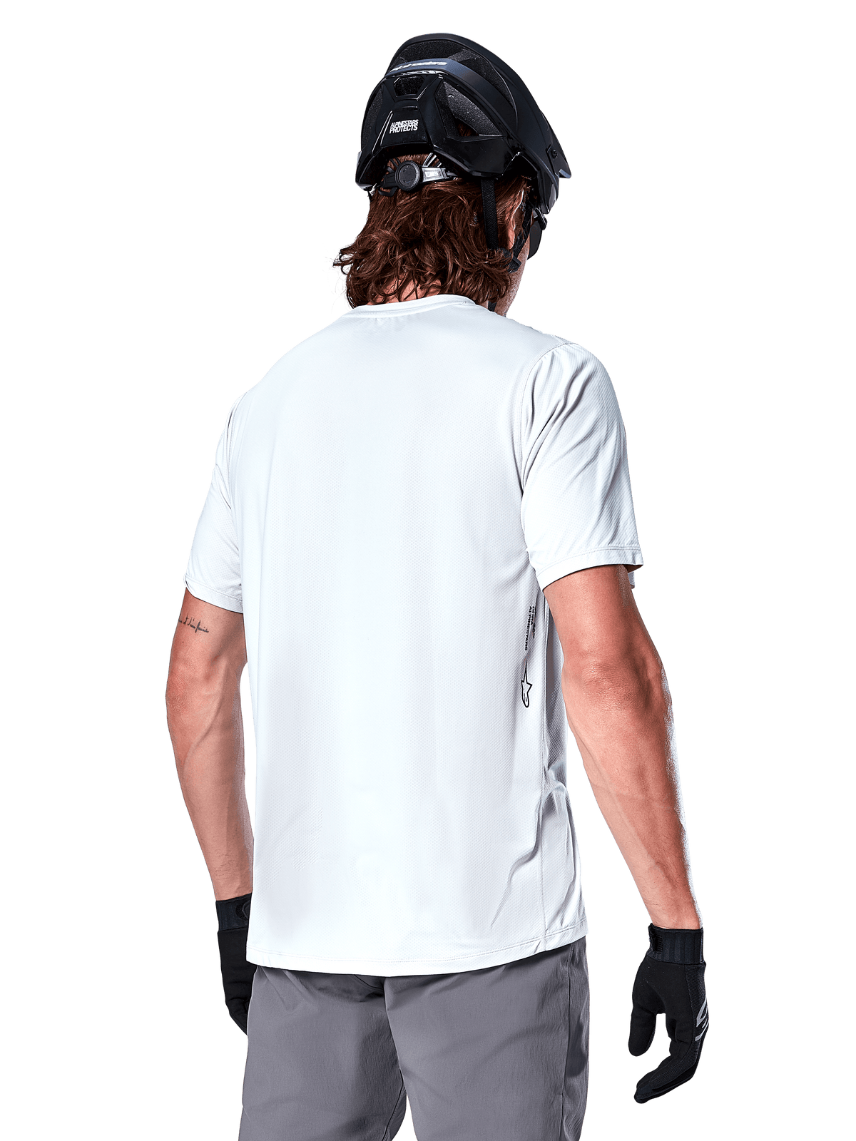 Alpinestars A-Dura Oscar Jersey, MTB-shirt met korte mouwen, White Dove, achteraanzicht van een rijder met een zwarte fietshelm, grijze short en zwarte handschoenen, technische fietskleding
