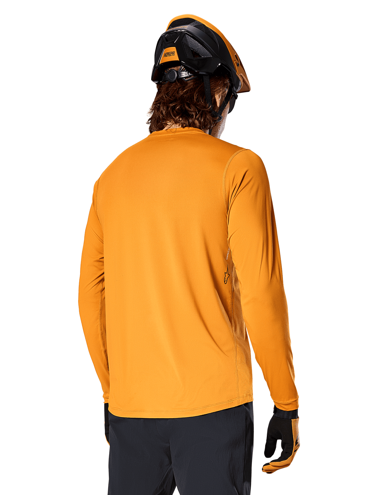 Maillot à manches longues Alpinestars A-Dura Rocker, Or foncé, vue arrière d'un cycliste portant un casque de VTT noir et orange, un pantalon sombre et des gants assortis, tenue de VTT décontractée et performante