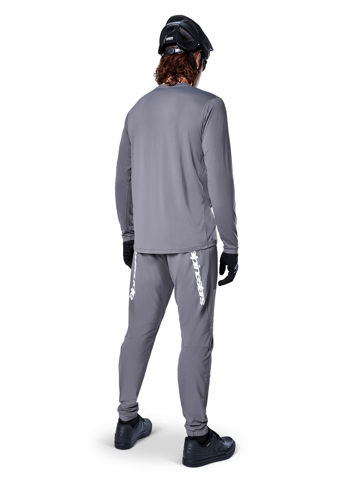 Maillot à manches longues Alpinestars A-Dura Rocker, gris foncé, vue arrière d'un mannequin portant un pantalon de VTT gris assorti, un casque noir et des gants noirs, design professionnel d'équipement de VTT