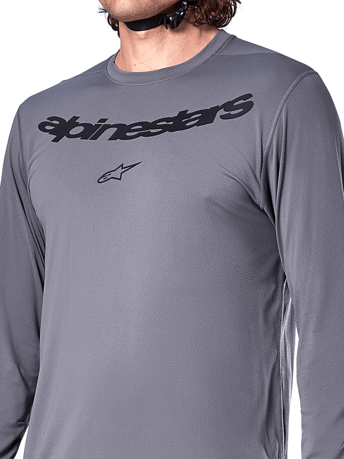 Maillot à manches longues Alpinestars A-Dura Rocker, gris foncé, gros plan sur la poitrine présentant le lettrage Alpinestars noir et le logo étoilé, matière jacquard poly-spandex, vêtement de performance pour VTT