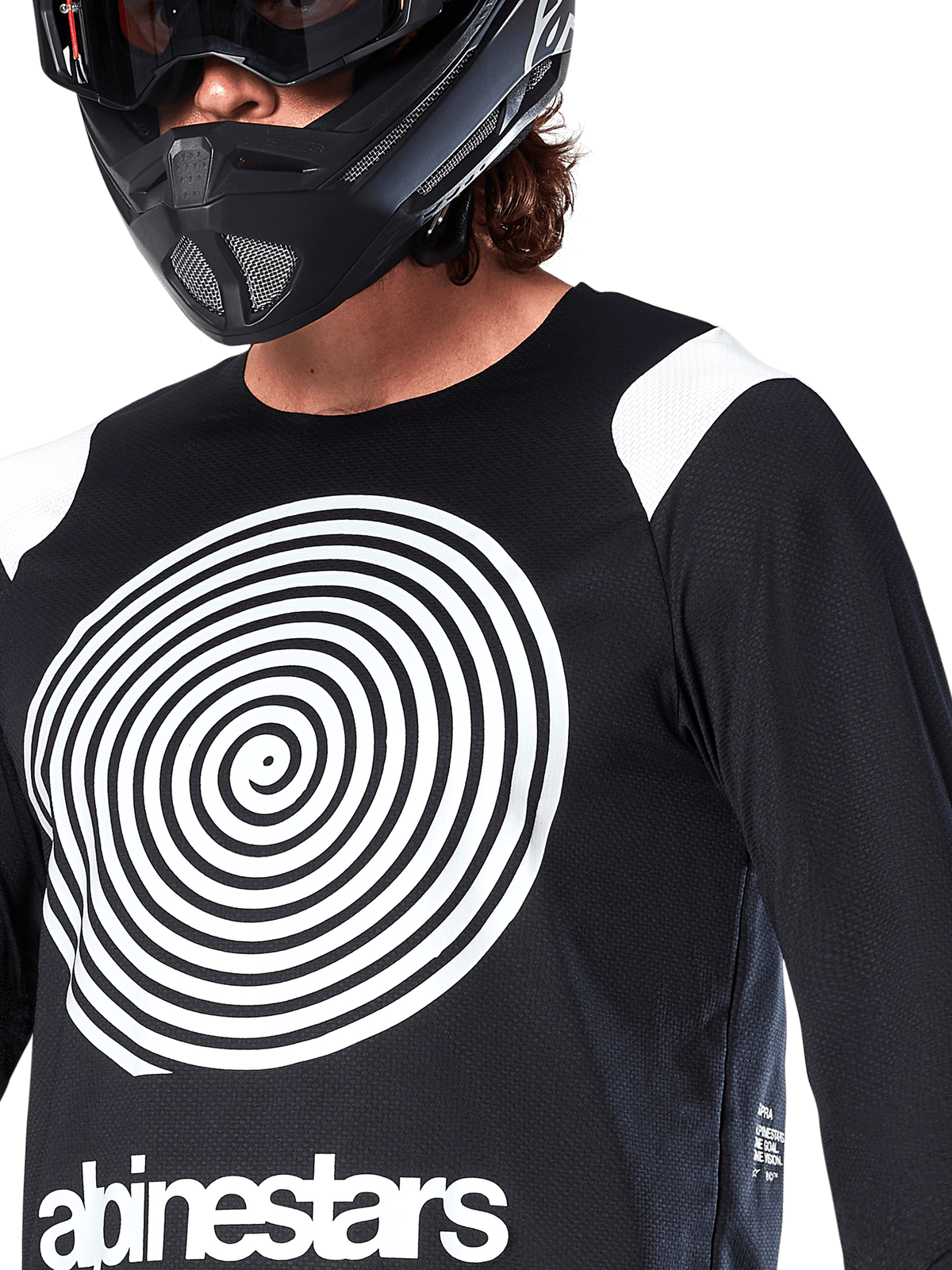 Alpinestars A-Supra Oscar Jersey, lange mouwen, zwart, met een grote witte Oscar spiraalgrafiek op de borst en merklogo, gedragen door een rijder met een zwarte full-face helm en bril, prestatiegerichte mountainbikekleding voor gravity riding