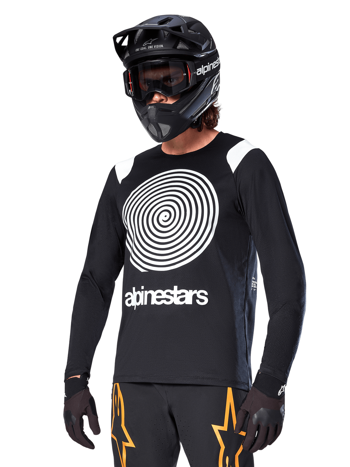 Alpinestars A-Supra Oscar Jersey met lange mouwen, MTB-fietsshirt, zwart en wit, voorzien van een opvallend wit spiraalontwerp en Alpinestars-logo op de borst, gedragen met een zwarte full-face helm en bril, prestatiegerichte mountainbikekleding