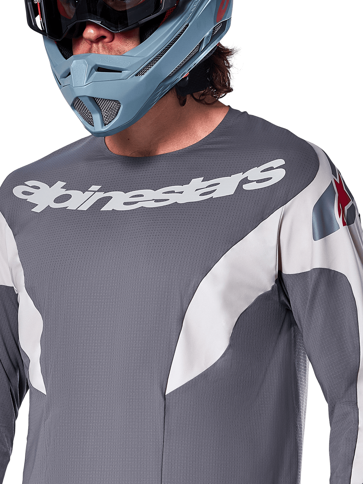 Alpinestars A-Supra Race Jersey - Manches longues, maillot de VTT, gris foncé avec graphismes de course blancs et logo Alpinestars blanc, porté avec un casque intégral bleu clair et des lunettes, tissu micro-perforé pour la performance tout-terrain