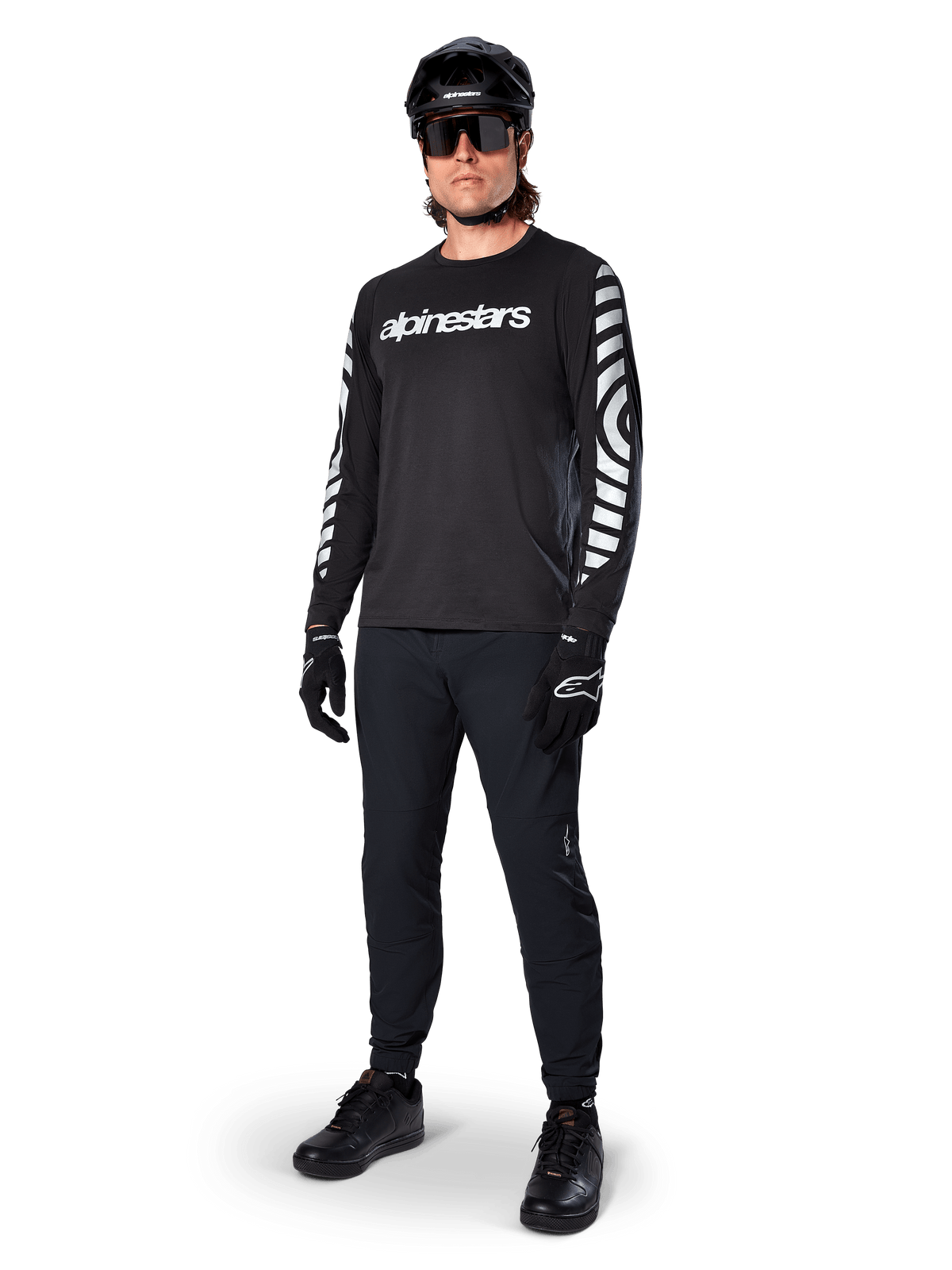Alpinestars A-Dura Dri Oscar Long Sleeve Jersey, Black Reflective, featuring bold white Alpinestars wordmark on chest and reflective graphic patterns on the sleeves, worn with black mountain bike pants, helmet, and gloves, technical MTB apparel
