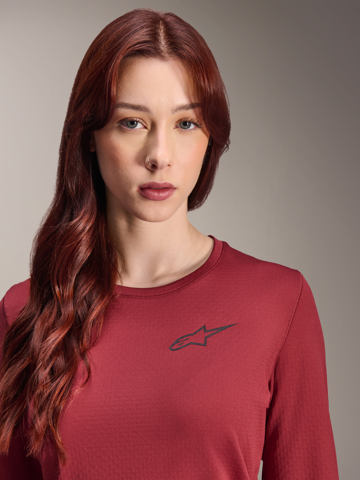 Alpinestars Stella A-Dura Thermal Jersey, MTB-jersey met lange mouwen voor dames, bordeauxrood, detailopname met een zwart sterlogo op de borst, geïsoleerde technische kleding voor mountainbiken in koud weer