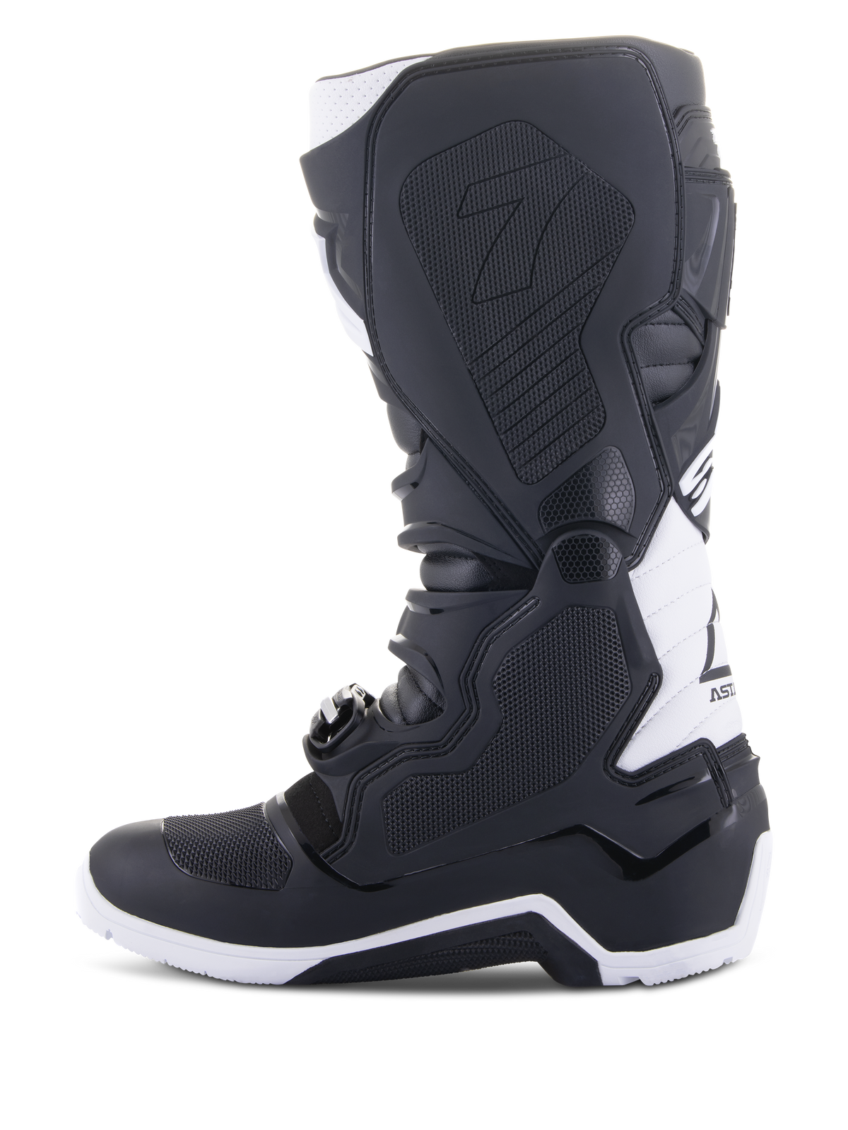 Bottes Alpinestars Tech 7 Enduro Drystar®, bottes de moto enduro, noir et blanc, vue du côté médial avec panneaux d'adhérence à texture en nid d'abeille, construction en TPU et accents blancs sur le talon et le haut du mollet, chaussures tout-terrain professionnelles