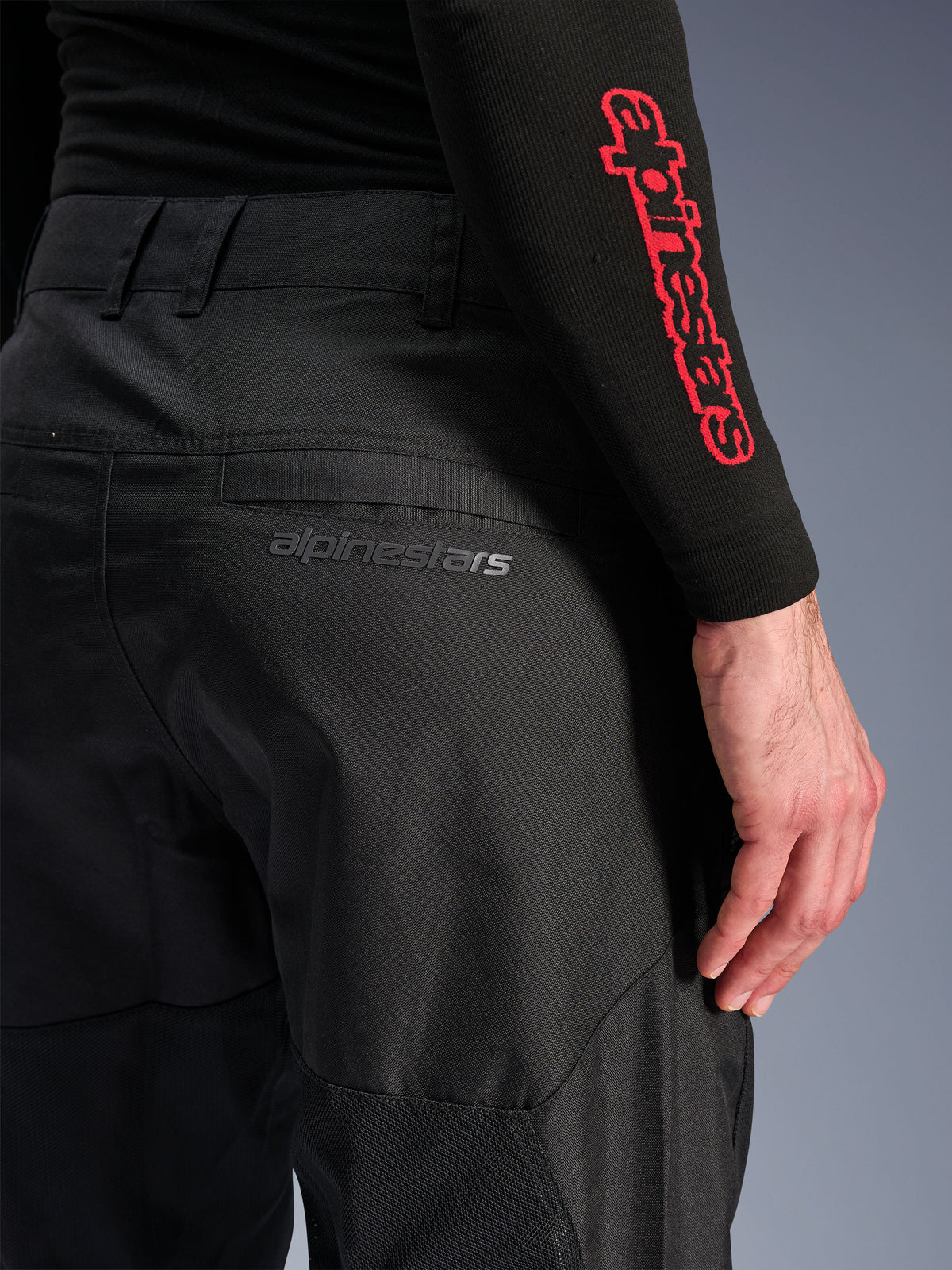 Pantalon Alpinestars C-1 Air, pantalon de moto en textile noir, vue rapprochée de la poche arrière avec un discret logo Alpinestars gris, doté de panneaux en mesh respirant et d'un polyfibre durable, conçu pour le confort de conduite urbaine
