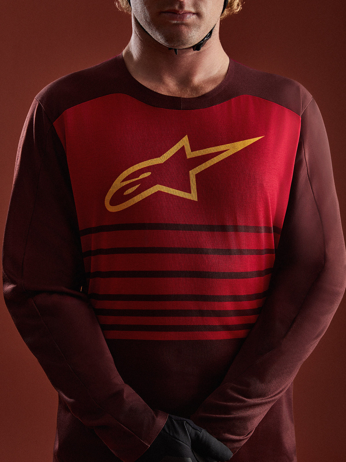 A-Dura Elite Langarmtrikot in Bordeaux mit rotem Brustpanel, gelbem A-Star-Logo und horizontalen Streifen.