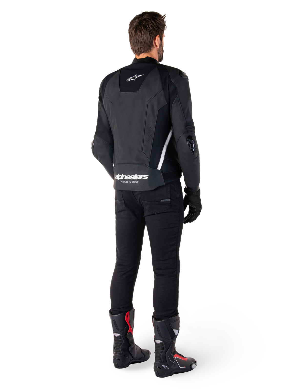 Alpinestars Missile V3 Leren Jas, zwart en wit, achteraanzicht op de rijder, met opvallende witte Alpinestars-branding op de onderrug en een klein logo op de bovenrug, gedragen met zwarte broek en racelaarzen, hoogwaardige leren constructie voor motorraces