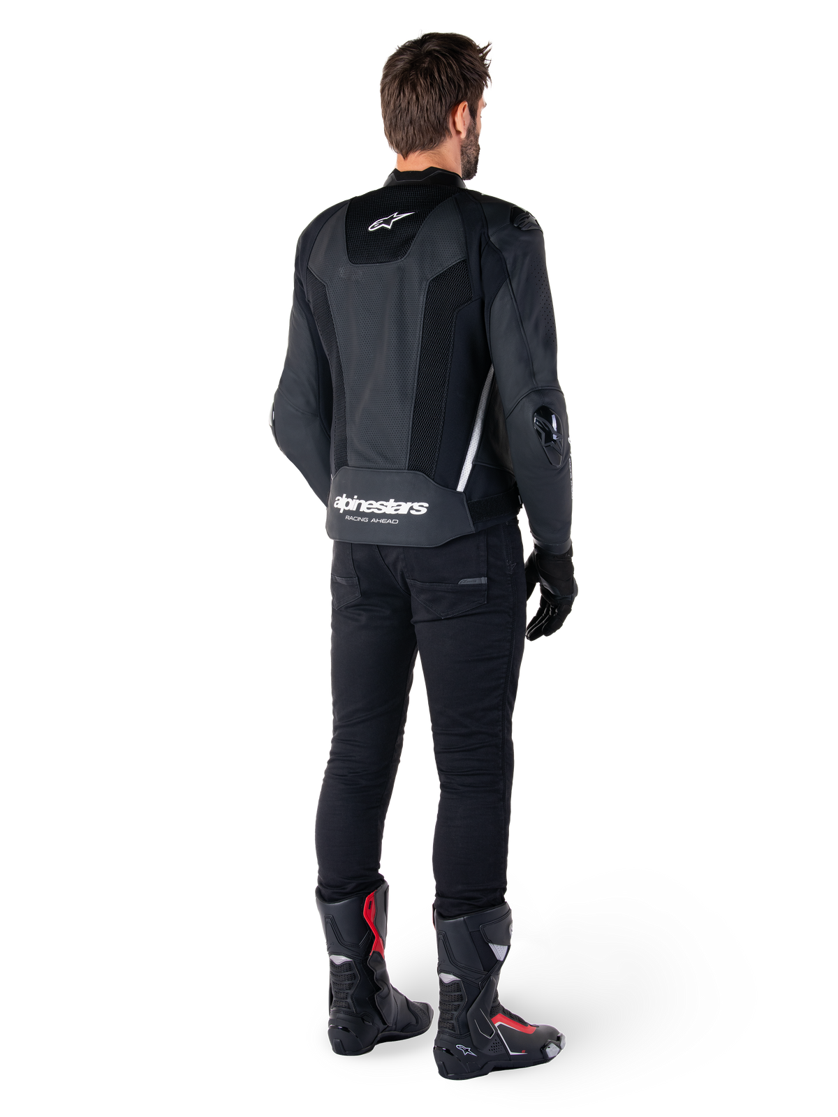 Alpinestars Missile V3 Airflow Lederjacke, Schwarz/Weiß, Rückansicht getragen mit schwarzer technischer Hose und Rennstiefeln, mit perforierten Leder-Rückeneinsätzen und markantem Alpinestars-Branding am unteren Rücken.