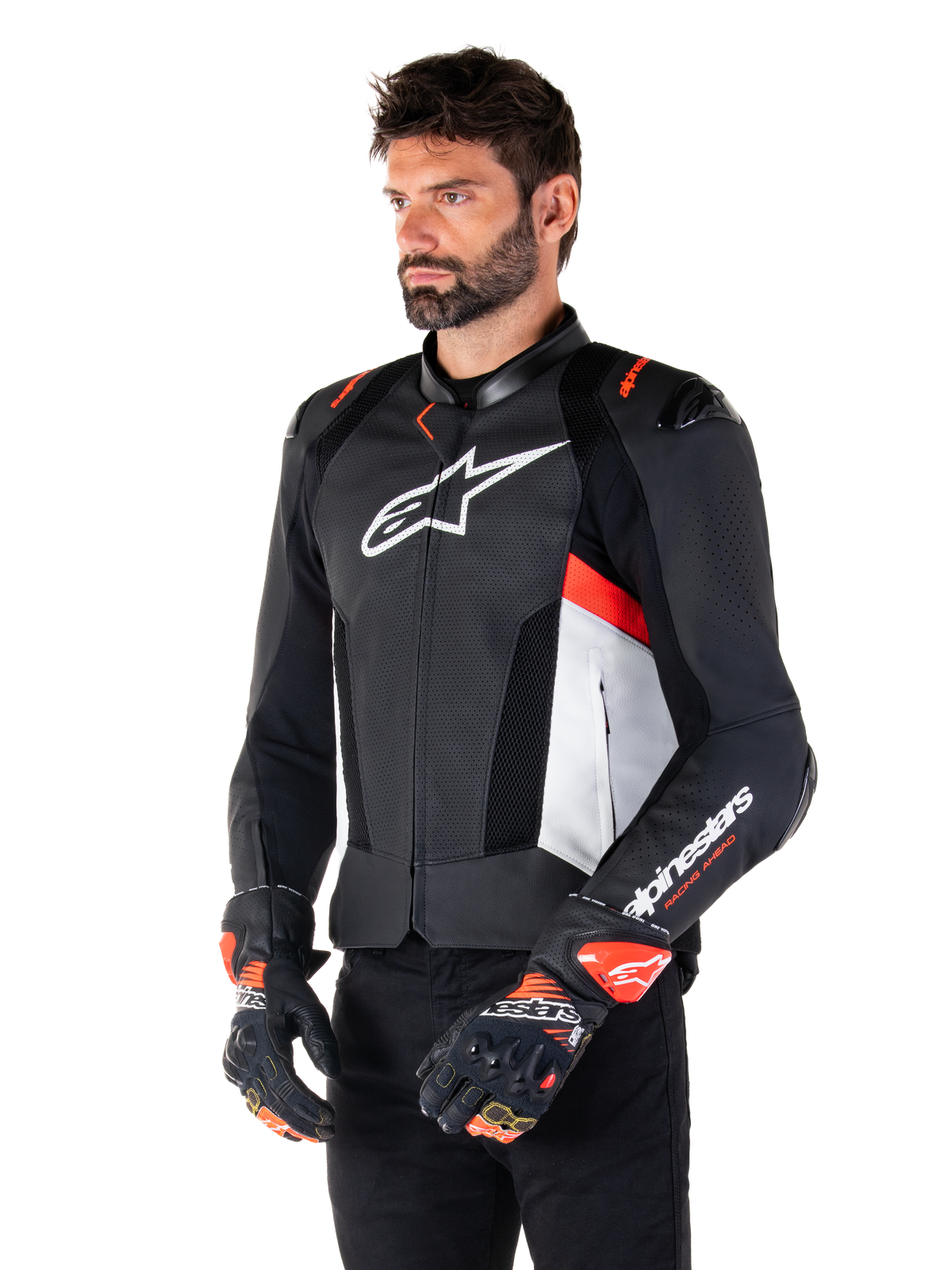 Alpinestars Missile V3 Airflow Lederjacke, Schwarz, Weiß und Fluo-Rot, Rennsport-Motorradjacke, getragen von einem Model mit passenden Handschuhen, mit perforierten Lederpanels, großem weißen Brust-Logo und schwarzen Schulterschleifern.