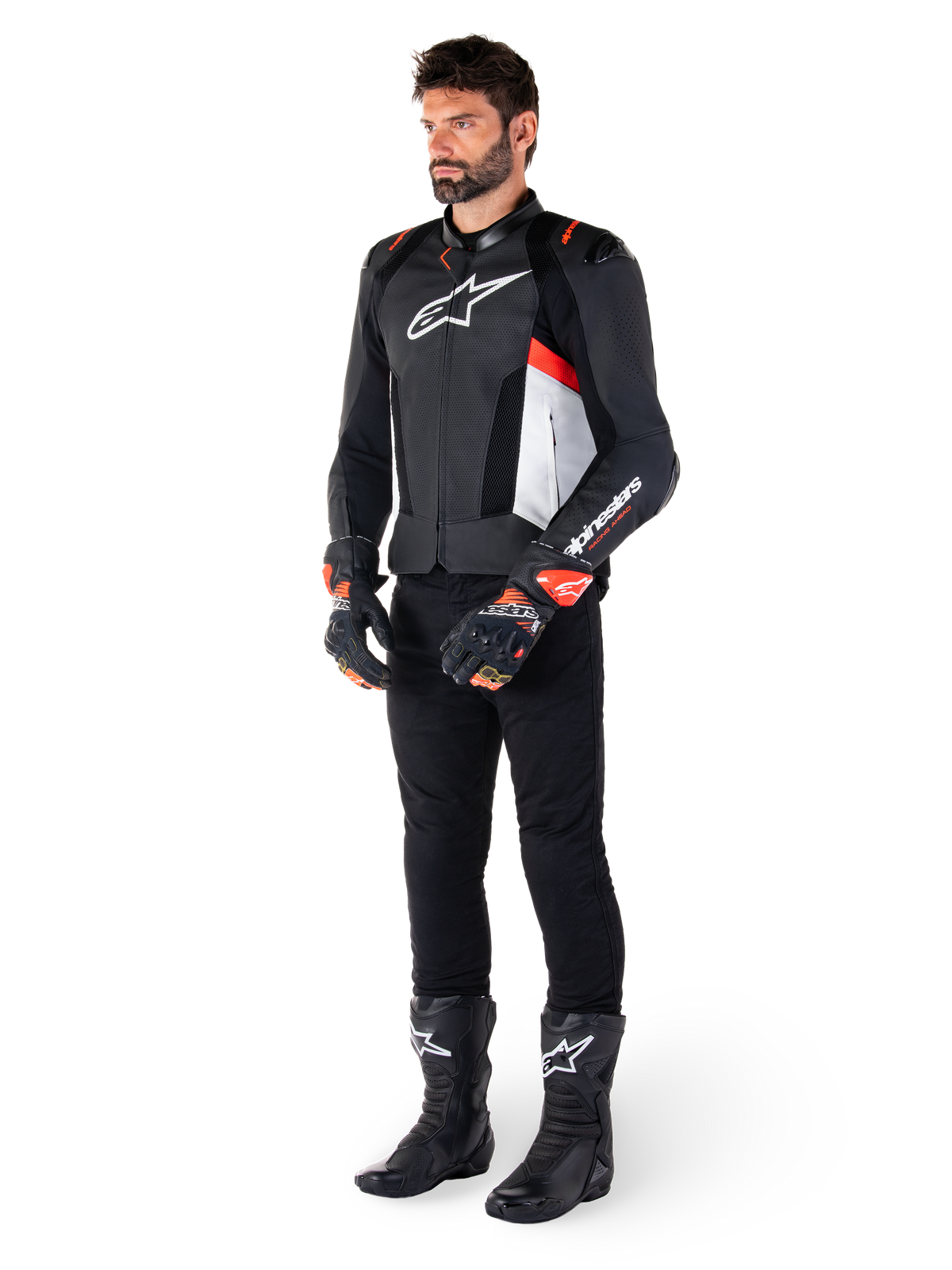 Alpinestars Missile V3 Airflow Lederjacke, Schwarz Weiß Rot Fluo, getragen von einem männlichen Model mit schwarzer Hose, schwarzen Rennhandschuhen und schwarzen Stiefeln, mit perforiertem Leder für Belüftung, weißem Brustlogo und fluoreszierenden roten Akzenten, entwickelt für erstklassige Renn- und Sport-Performance.