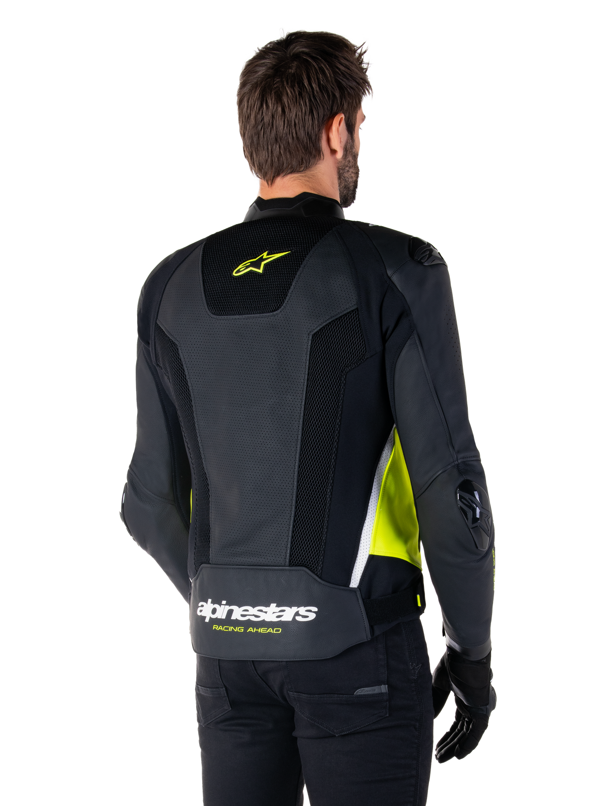 Alpinestars Missile V3 Airflow Lederjacke, Rückansicht an einem männlichen Modell, Schwarz mit neongelben und weißen Akzenten, großflächige perforierte Leder- und Mesh-Einsätze am Rücken, gelbes Stern-Logo und weißer „RACING AHEAD“-Schriftzug, kombiniert mit schwarzen Handschuhen und einer schwarzen Hose.
