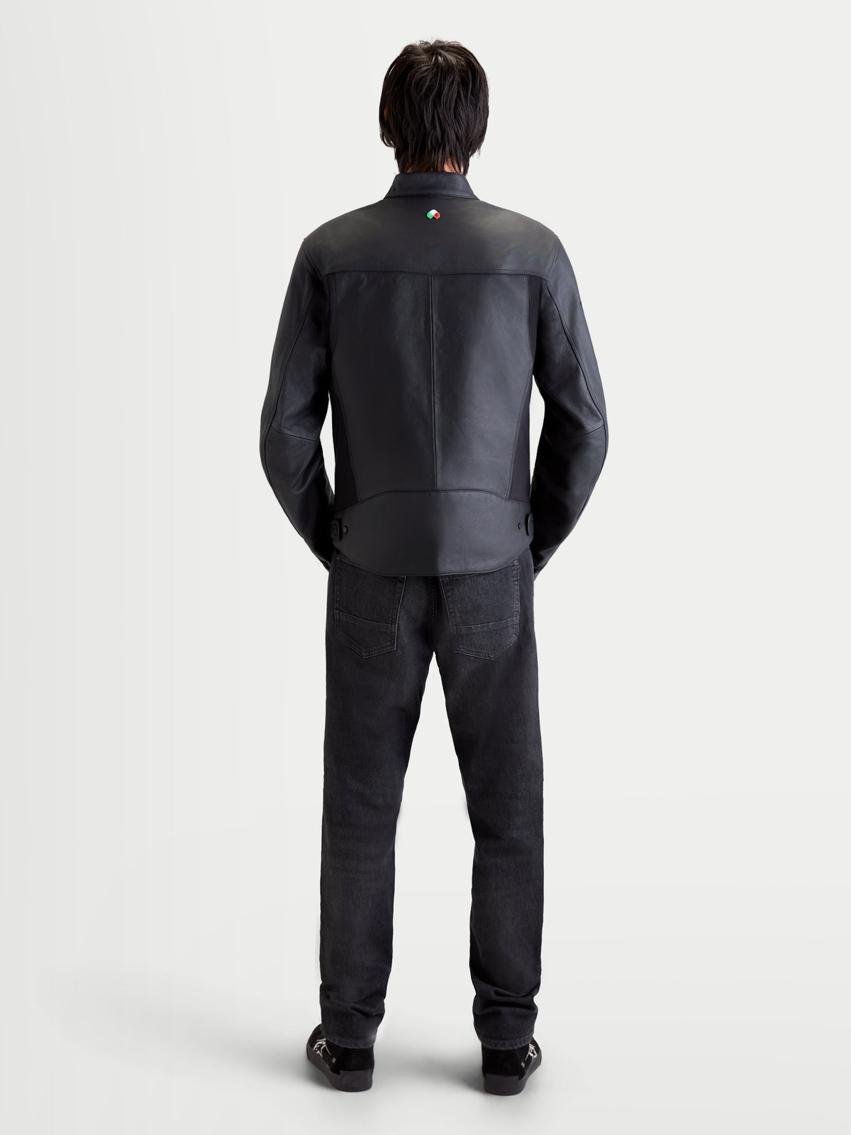 Alpinestars Maver-X Leather Jacket, men's urban contemporary motorcycle jacket in black, rear view on a model wearing matching dark jeans and shoes, showing premium leather construction and collar detail.