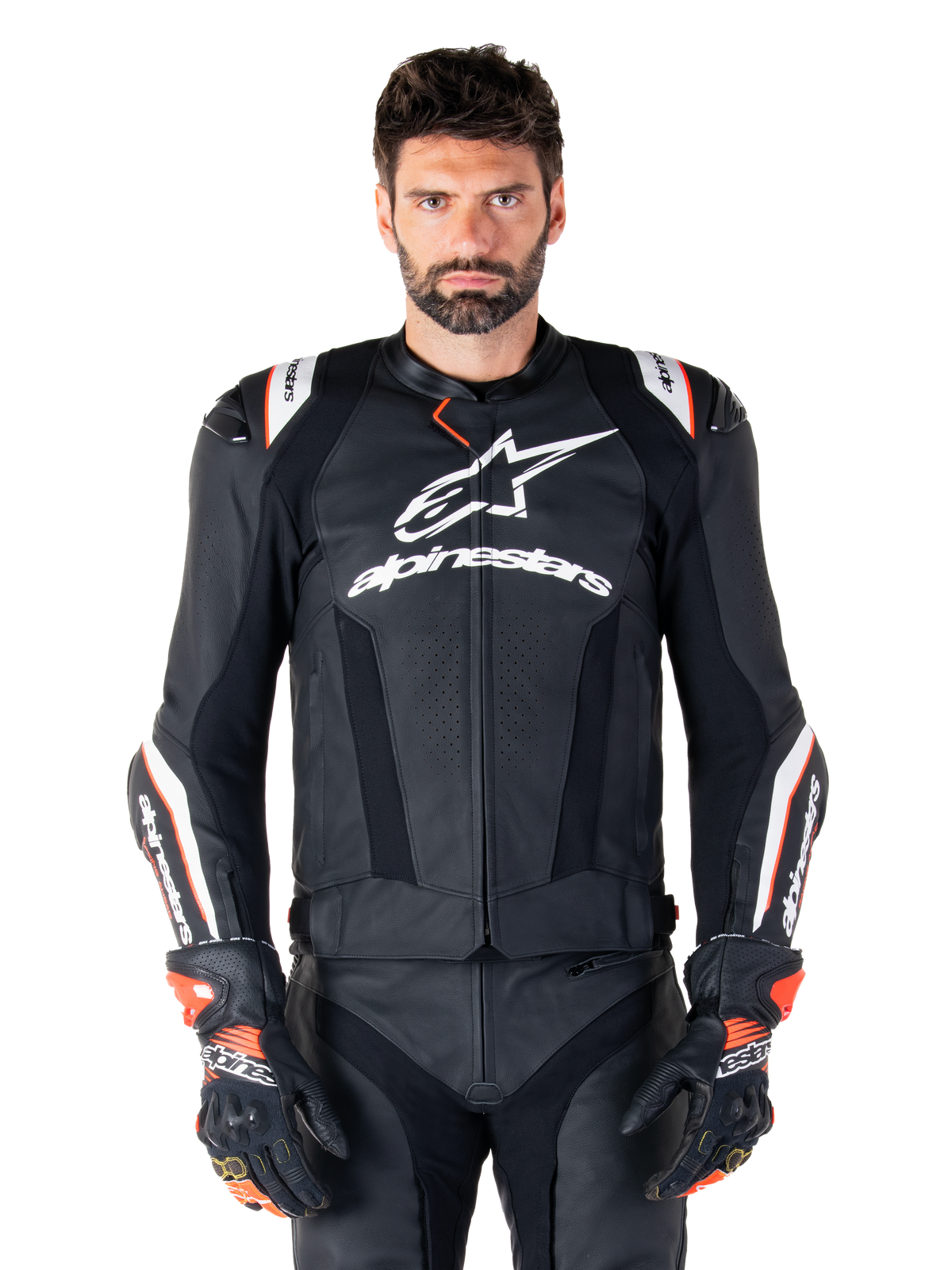 Alpinestars Missile V3 Ignition Leren Jas, zwart met witte en rode accenten, gedragen door een mannelijk model met bijpassende racehandschoenen en broek, sportmotorjas afgeleid van de MotoGP met opvallende branding