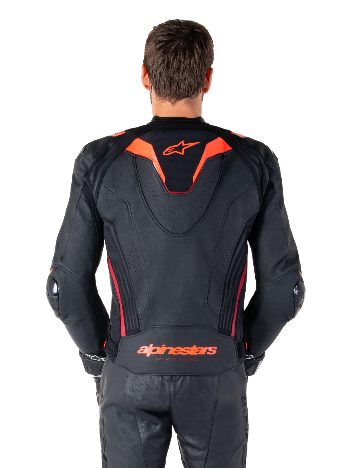 Alpinestars Missile V3 Ignition leren jas, achteraanzicht, zwart met Red Fluo en Dark Red accenten, voorzien van een sportieve aero-hump, Alpinestars-branding op de rug, gedragen met bijpassende zwarte leren motorbroek, hoogwaardige motorrace-uitrusting