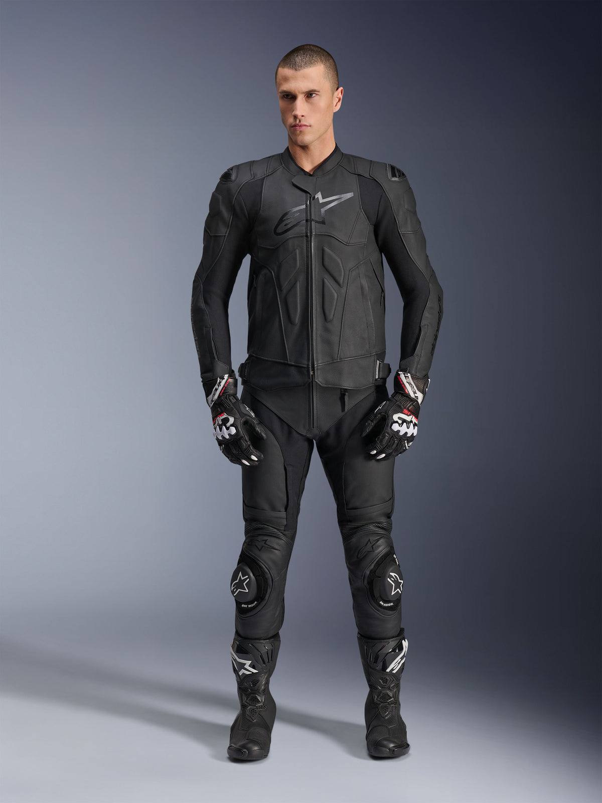 Alpinestars Dusk Lederjacke, sportliche Motorradjacke für Herren, Schwarz, aus Rindsleder, Tech-Air® Ready, getragen von einem Model mit passender Lederhose und Stiefeln.