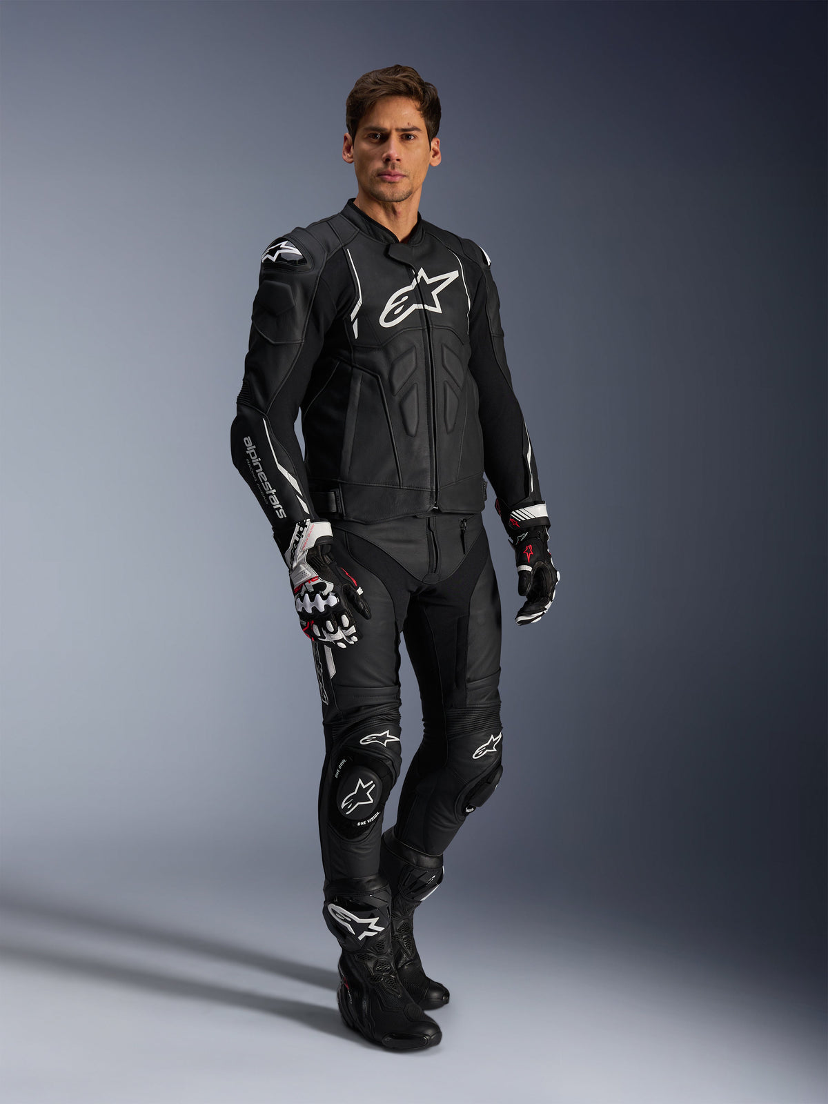 Alpinestars Missile V3 Lederhose und passende schwarze Lederjacke, komplette Motorrad-Rennkombi, schwarz mit weißem Alpinestars-Branding auf Brust und Knien, inklusive professioneller Rennhandschuhe und Stiefel, elegante Schutzausrüstung für Straße und Rennstrecke.