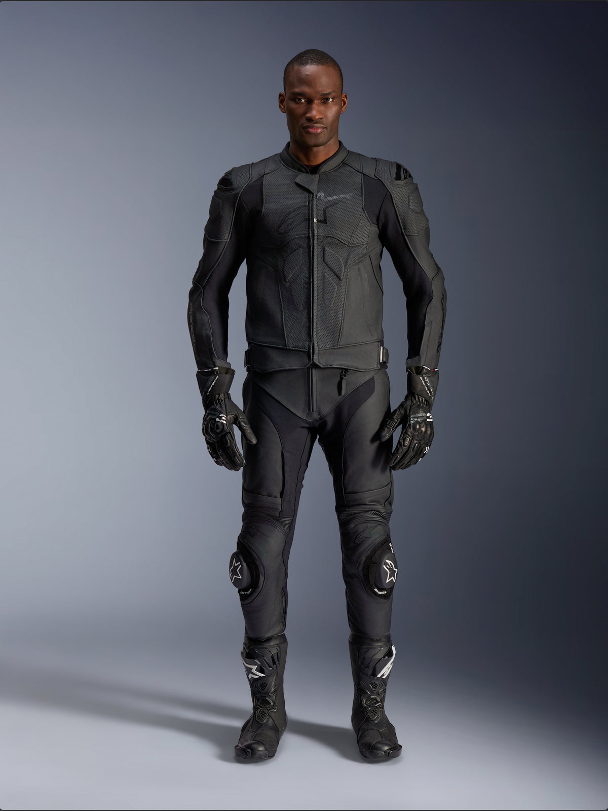 Veste en cuir Alpinestars Dusk Airflow, noire, portée avec pantalon, gants et bottes de moto assortis, avec cuir perforé pour un flux d'air maximal, design ergonomique multi-panneaux et protections internes, équipement de route et de sport professionnel