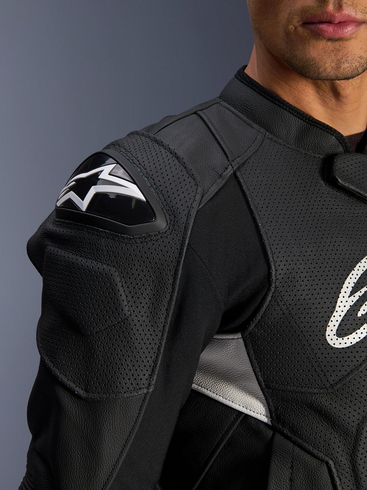 Veste en cuir Alpinestars Dusk Airflow, noir et blanc, vue rapprochée de l'épaule et du torse, avec cuir perforé pour la ventilation, protection d'épaule DFS avec logo Alpinestars blanc, design sportif.