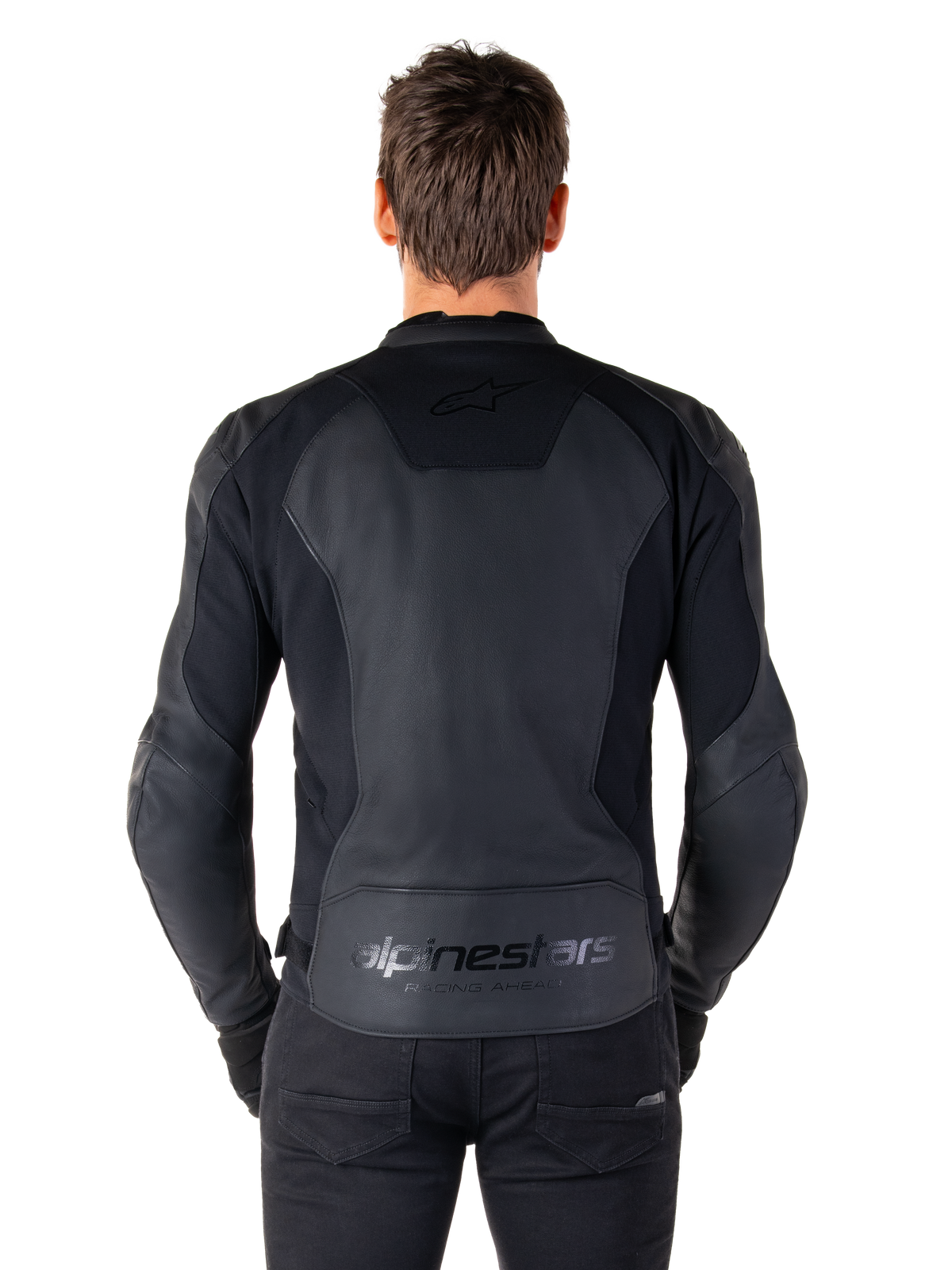 Rückansicht eines Mannes in der Alpinestars Faster V3 Lederjacke in Schwarz, mit hochwertigen Lederbahnen und flexiblen Stretcheinsätzen, dezentes „alpinestars“- und „RACING AHEAD“-Branding am unteren Rücken, sportliche Passform für Motorradfahrer