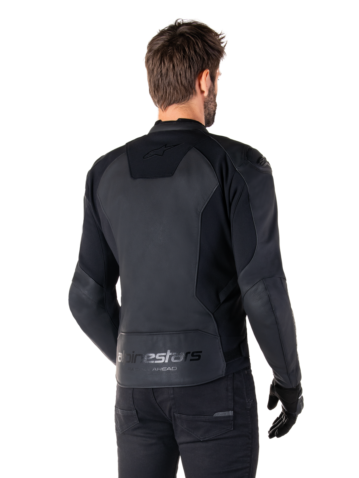 Alpinestars Faster V3 Lederjacke, Schwarz, Rückansicht eines Models in der Sport-Motorradjacke, mit 'alpinestars' und 'RACING AHEAD' Branding am unteren Rücken, erstklassiges Leder mit matten Einsätzen, moderne sportliche Silhouette für das Motorradfahren