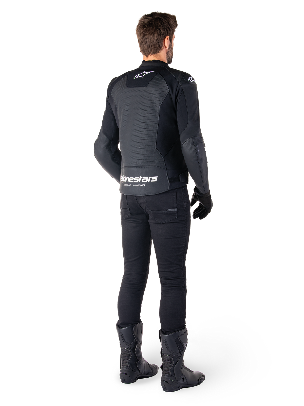 Alpinestars Faster V3 Airflow leren jas, zwart en wit, achteraanzicht met geperforeerde leren panelen en opvallende Alpinestars-branding op de onderrug, gedragen door een motorrijder met zwarte motorbroek, handschoenen en laarzen