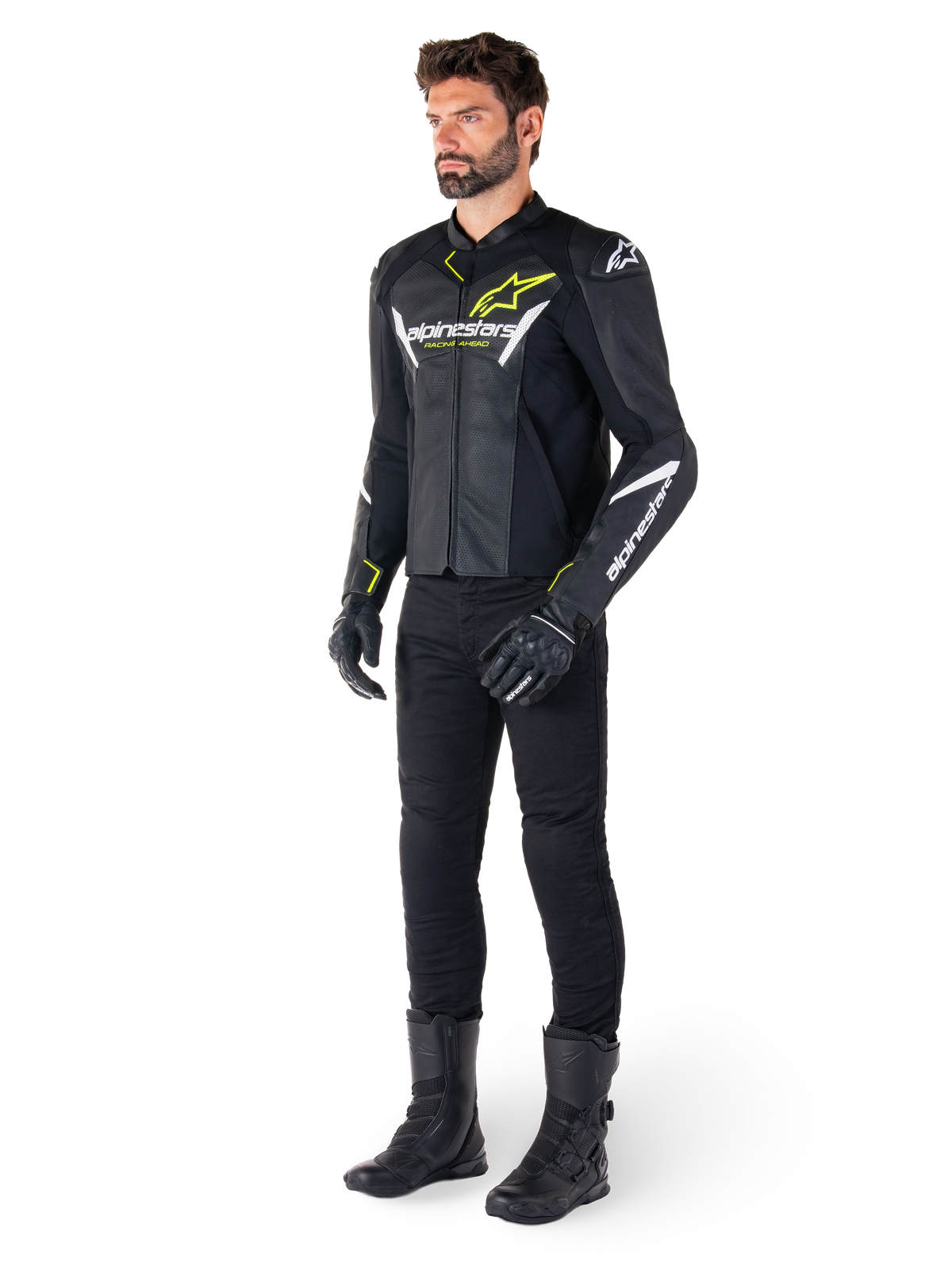 Männlicher Fahrer mit der Alpinestars Faster V3 Airflow Lederjacke in Schwarz, Weiß und Neongelb, kombiniert mit schwarzer Motorradhose und Stiefeln, mit perforierten Ledereinsätzen, weißen Logo-Details und neongelben Akzenten, professionelle Sport-Fahrerausrüstung