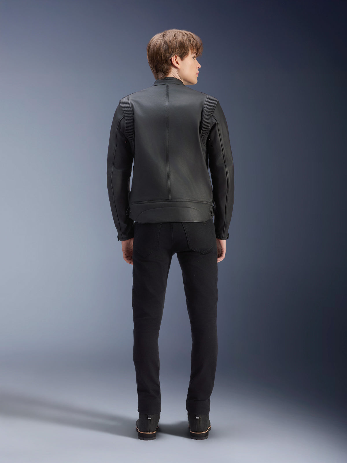 Alpinestars Dyno leren jas, urban herenmotorjas van zwart rundleer, achteraanzicht op model met accordeonpanelen.