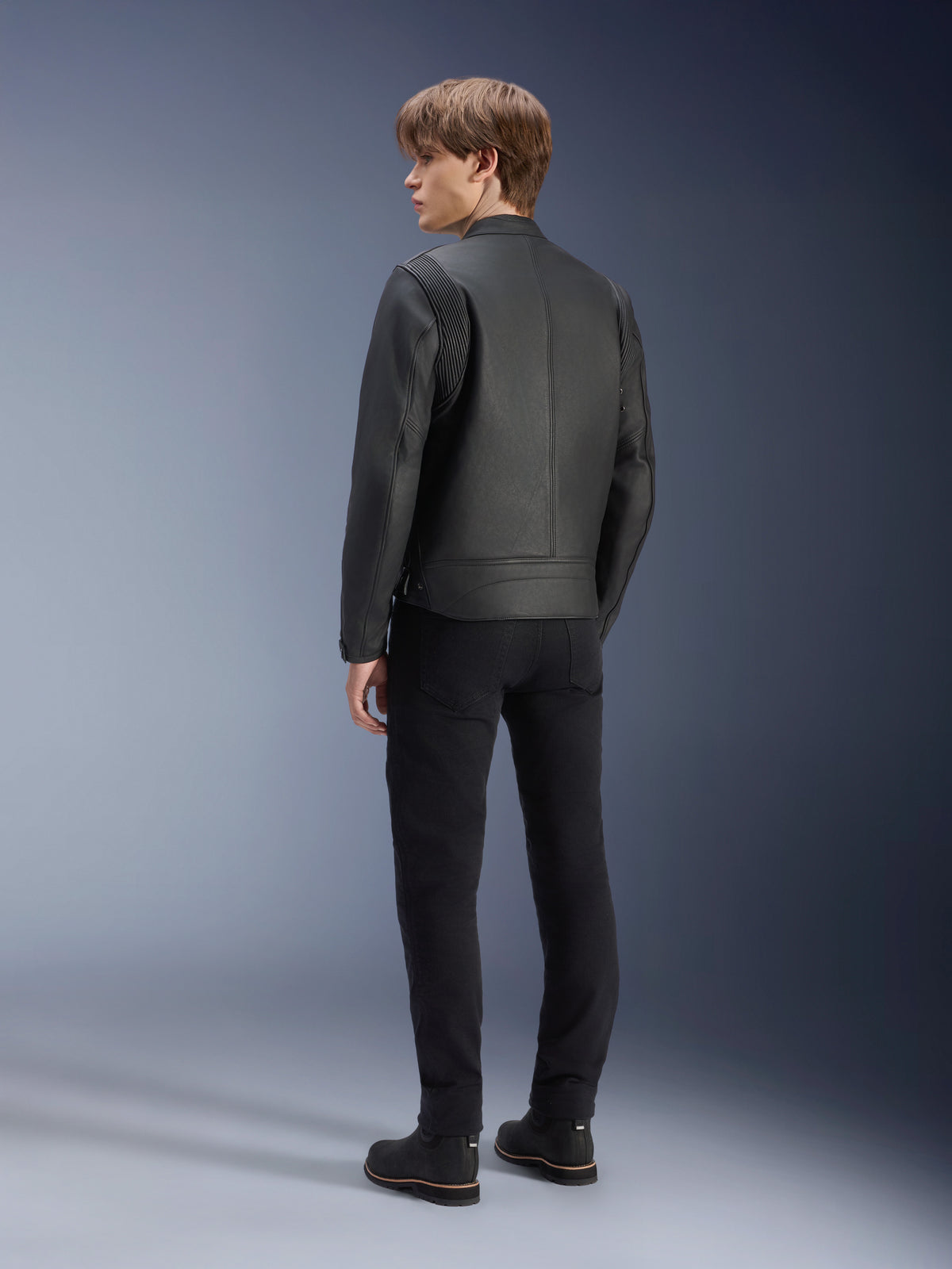 Alpinestars Dyno zwarte leren motorjas, urban stijl, achteraanzicht op mannelijk model met geribbelde schouderpanelen.