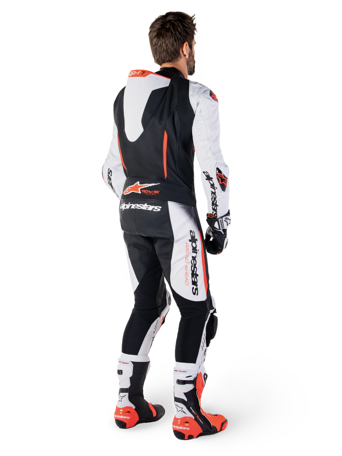 Alpinestars GP-R7, combinaison en cuir de course pour homme, blanche et noire, avec bosse aérodynamique, Tech-Air ready, vue de dos sur un pilote avec bottes et gants professionnels.