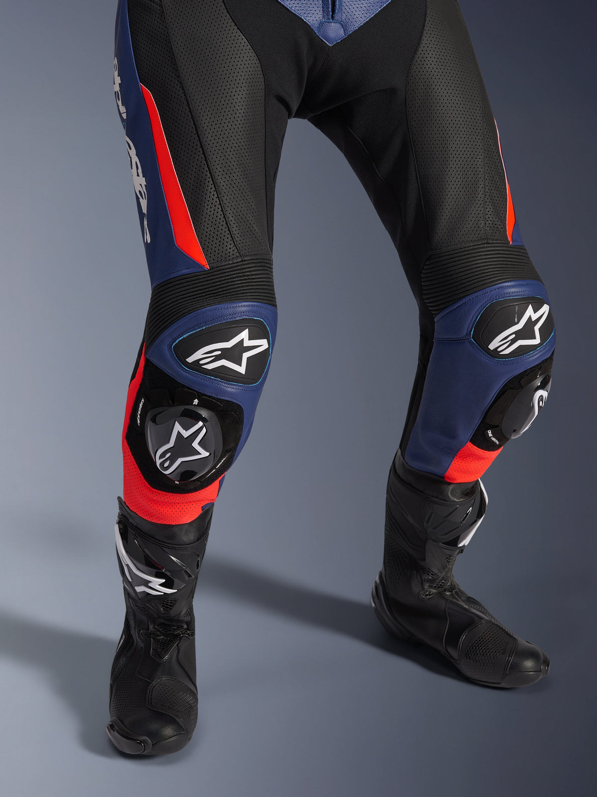Alpinestars GP Force V2 Lederkombi - 2-teilig, Motorrad-Rennkombi, Schwarz, Blau und Fluo-Rot, mit perforiertem Leder, Akkordeon-Knieeinsätzen mit Schutzschleifern und Alpinestars Logo-Branding, kombiniert mit schwarzen Rennstiefeln