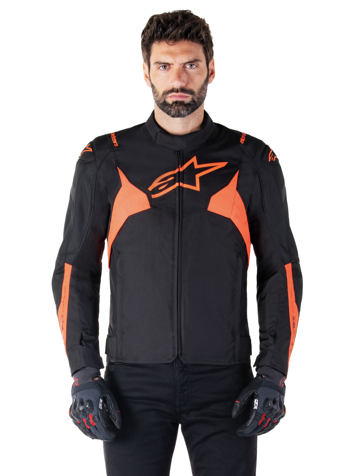 Alpinestars T-Jaws V4 Waterproof Jacket, veste de moto sport, noir et rouge fluo, avec des accents néon et un logo étoile proéminent sur la poitrine, portée par un modèle masculin avec des gants de moto noirs, design textile épuré inspiré de la course